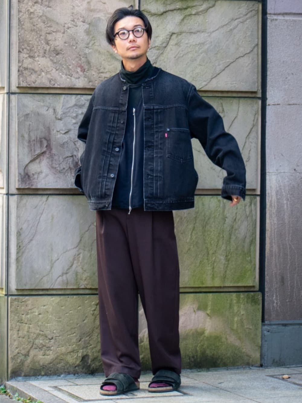 ブラック系のデニムジャケット、ブラウン系のスラックスを着用したメンズの冬コーディネートの1枚目の写真