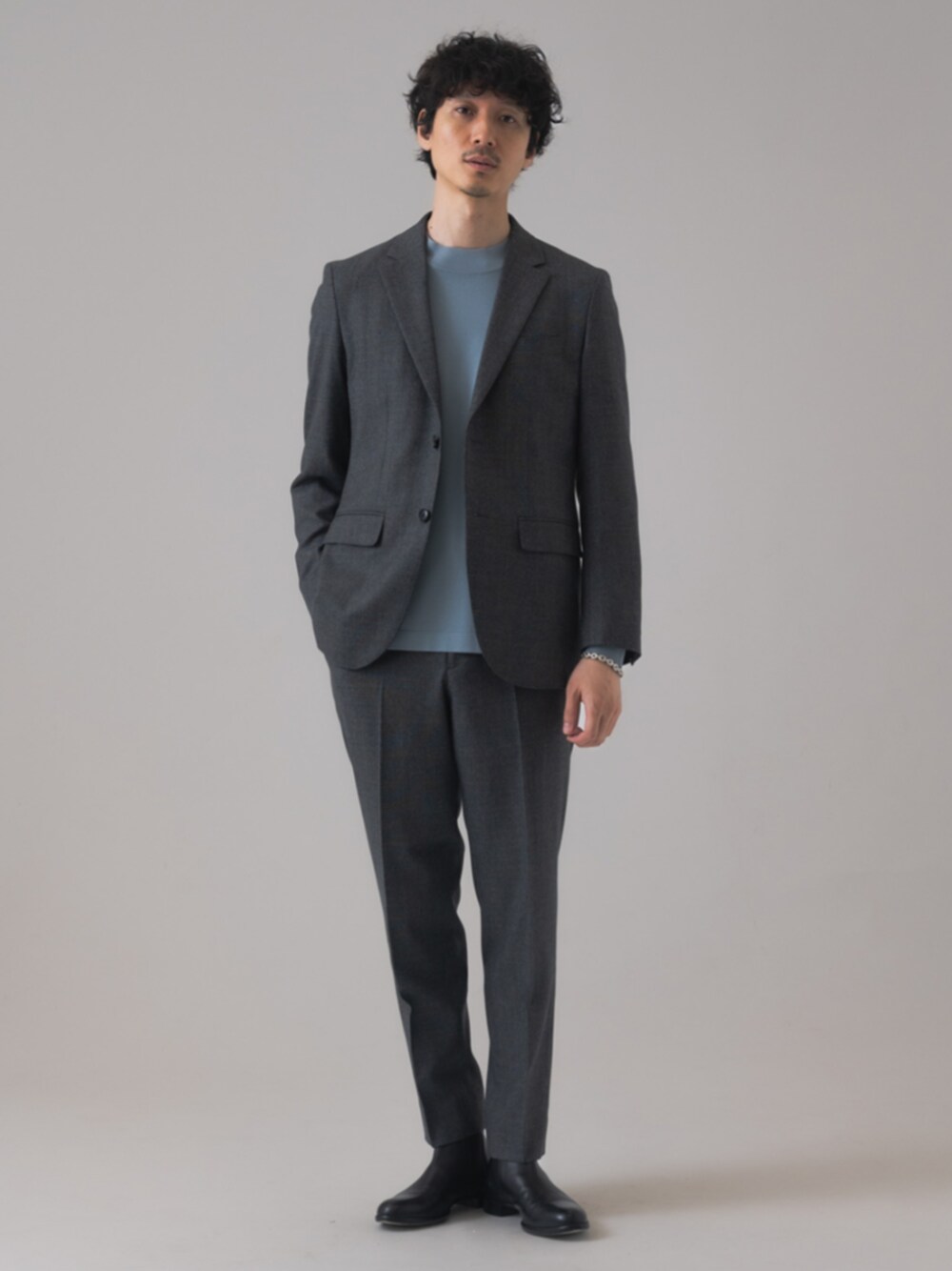ブラック系のブーツ、グレー系のテーラードジャケット、グレー系のスラックスを着用したメンズの秋コーディネートの1枚目の写真