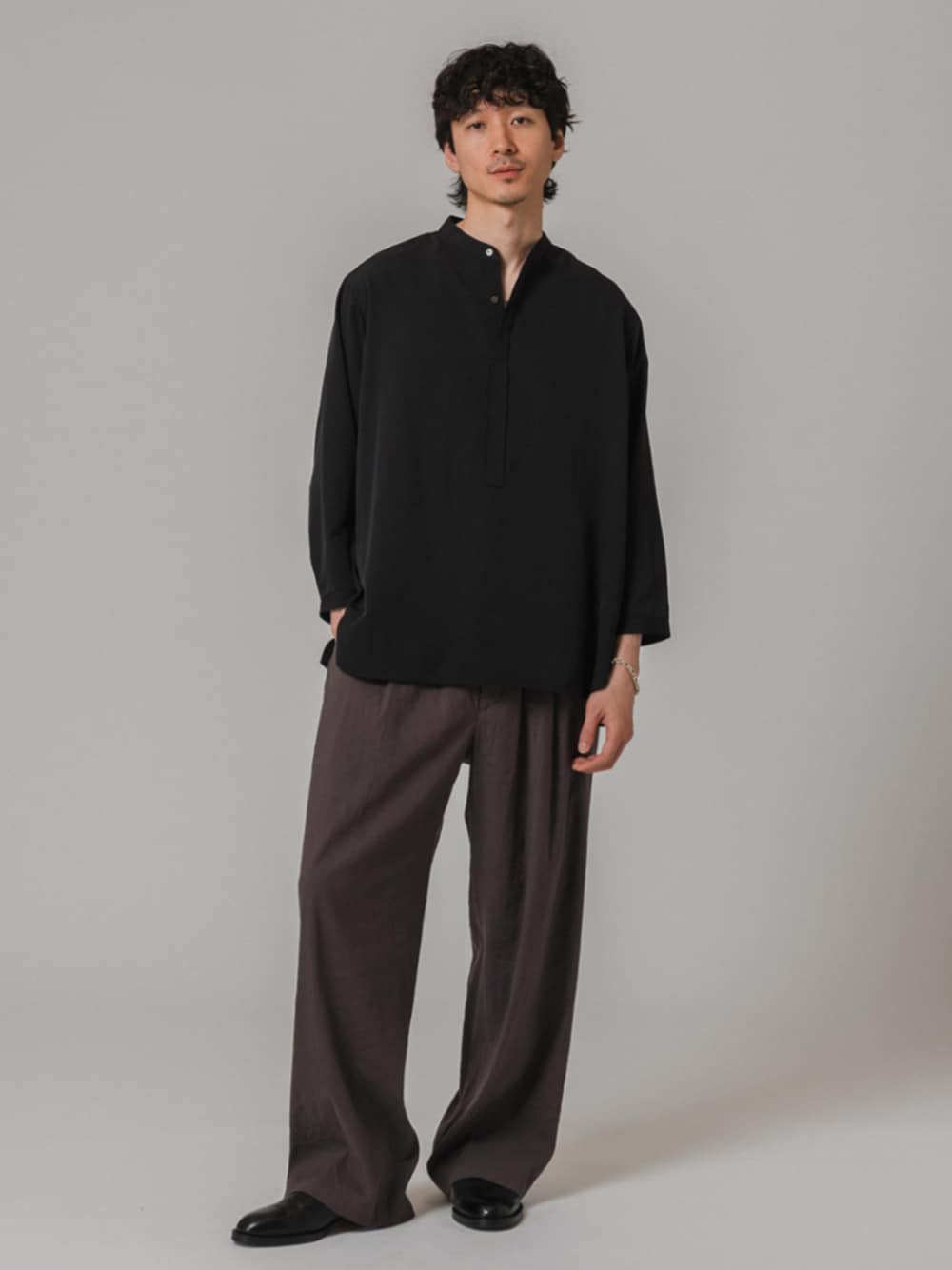 グレー系のスラックス、ブラック系のシャツ/ブラウスを着用したメンズの春コーディネートの1枚目の写真