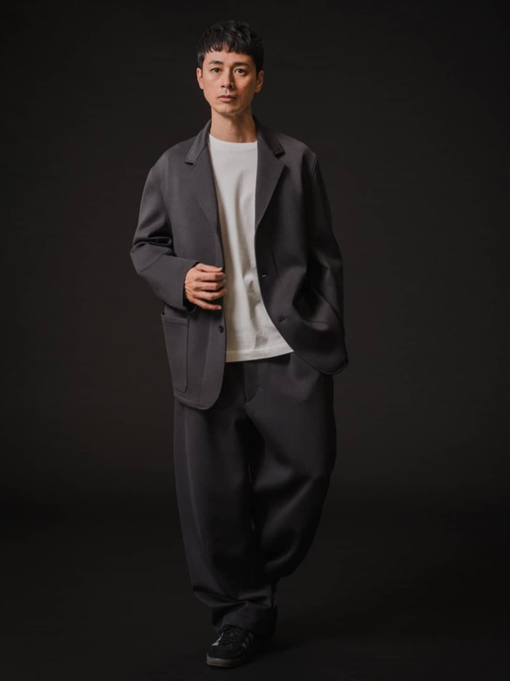 グレー系のテーラードジャケット、グレー系のスラックスを着用したメンズの冬コーディネートの1枚目の写真