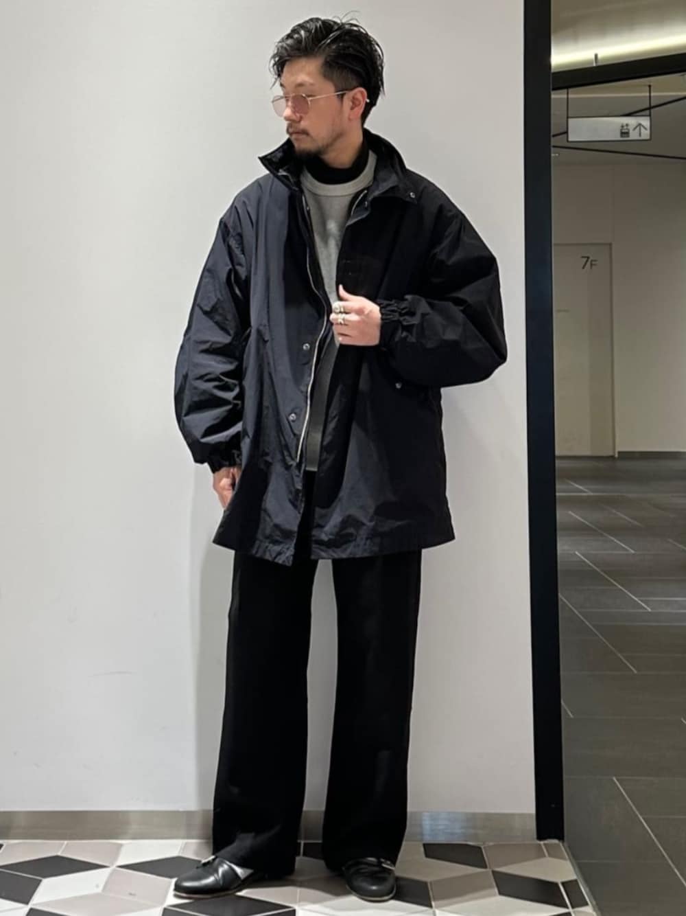 ブルー系のモッズコート、ブラック系のスラックスを着用したメンズの冬コーディネートの1枚目の写真