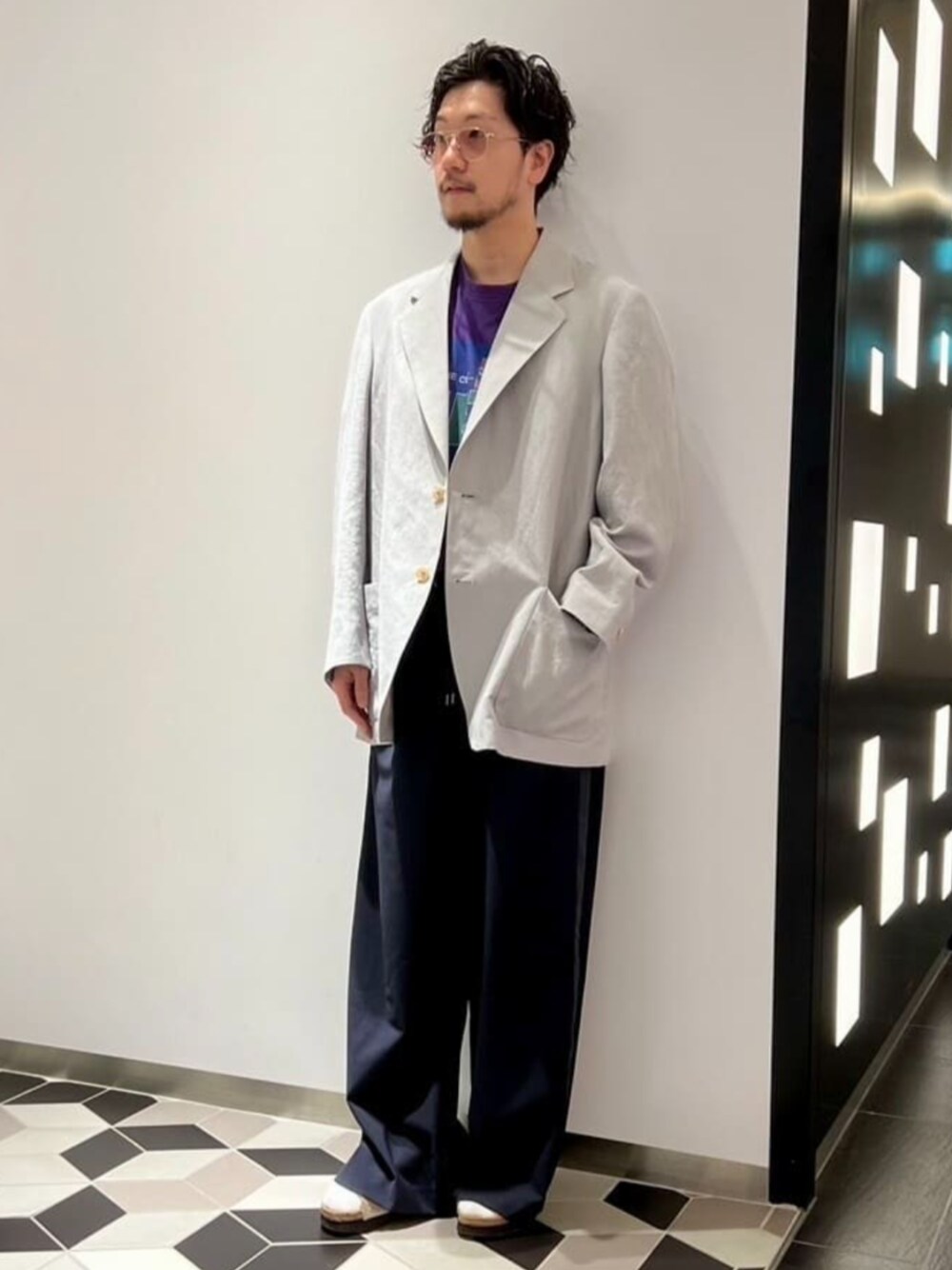 ブルー系のスラックス、グレー系のテーラードジャケット、パープル系のTシャツ/カットソーを着用したメンズの秋コーディネートの1枚目の写真