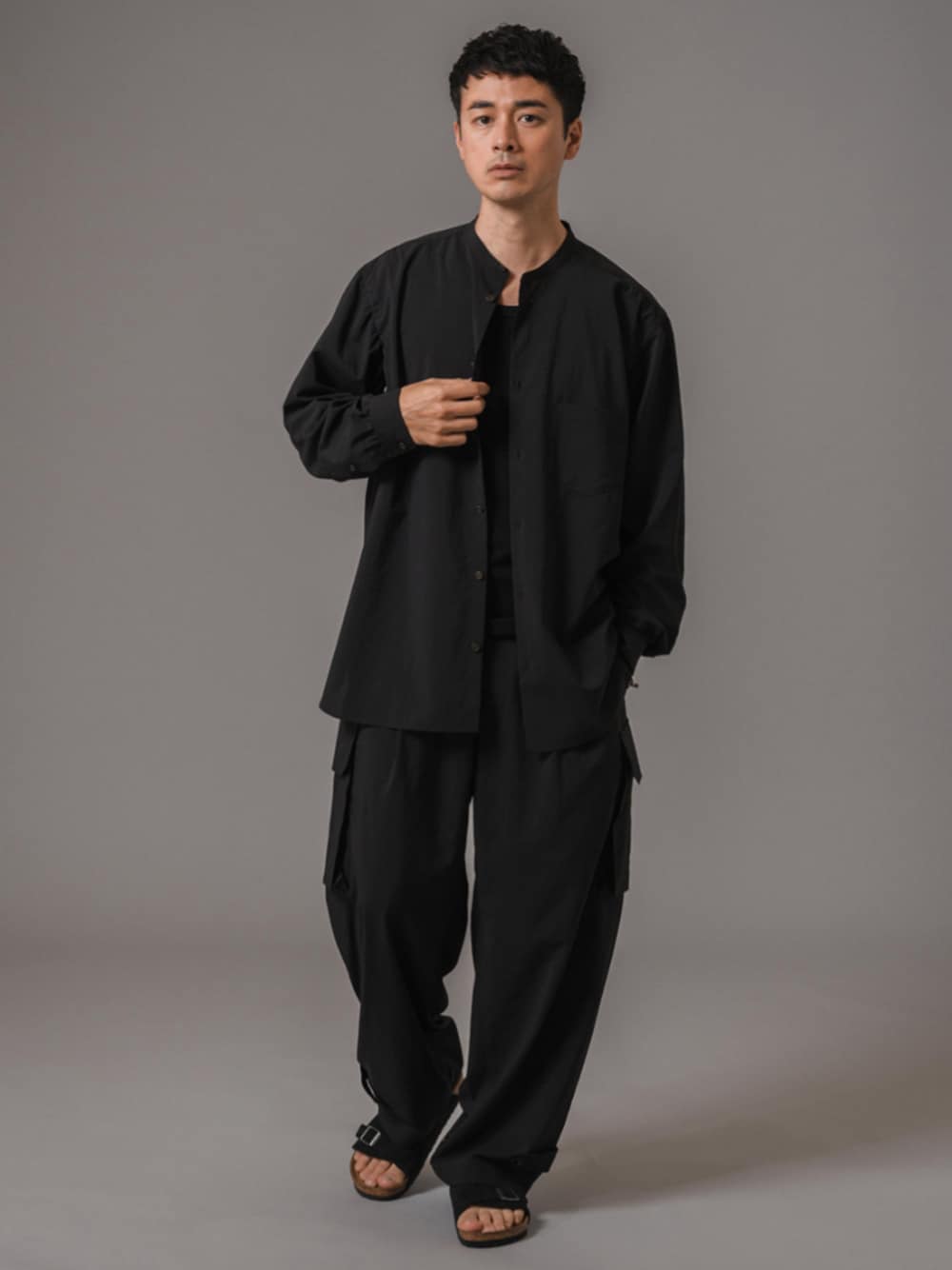 ブラック系のタンクトップ、ブラック系のカーゴパンツ、ブラック系のサンダルを着用したメンズの夏コーディネートの1枚目の写真