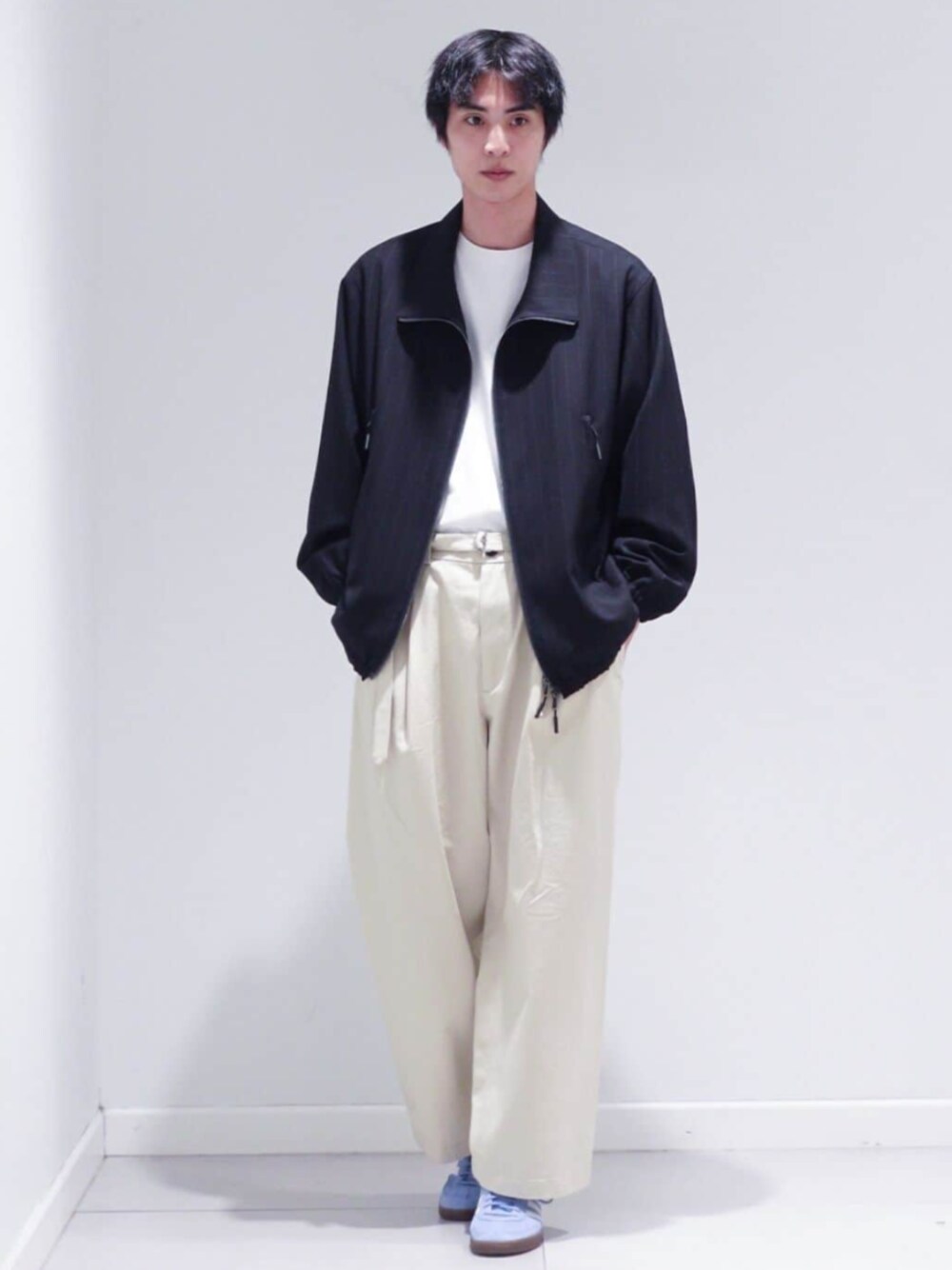 ホワイト系のスラックス、その他のその他アウター、ブルー系のスニーカーを着用したメンズの冬コーディネートの1枚目の写真