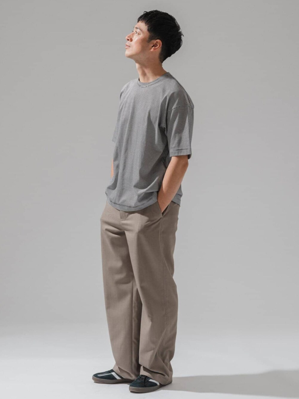 ブラウン系のスラックス、ブラック系のTシャツ/カットソーを着用したメンズの春コーディネートの1枚目の写真