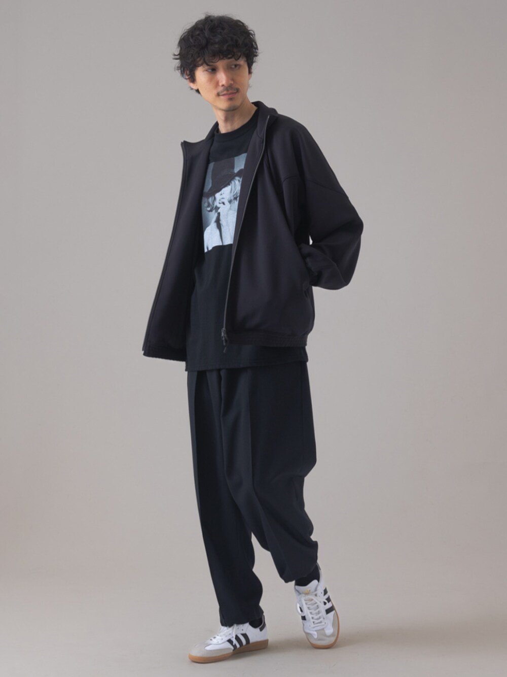 ホワイト系のスニーカー、ブラック系のスラックス、ブラック系のその他トップスを着用したメンズの秋コーディネートの1枚目の写真