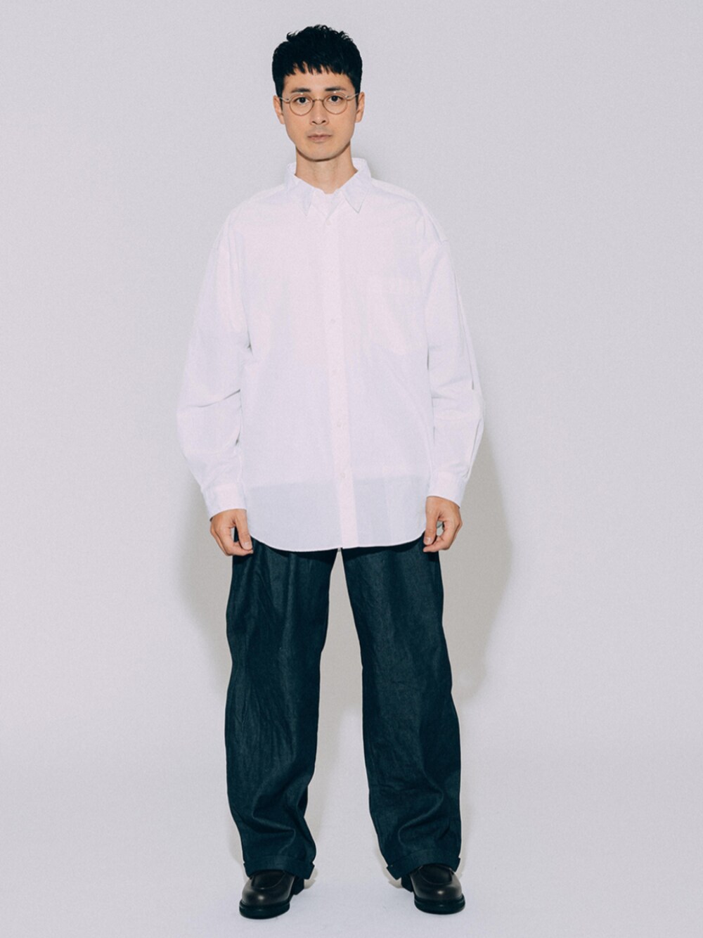 ブラック系のブーツ、ホワイト系のシャツ/ブラウス、ブルー系のデニムパンツを着用したメンズの冬コーディネートの1枚目の写真