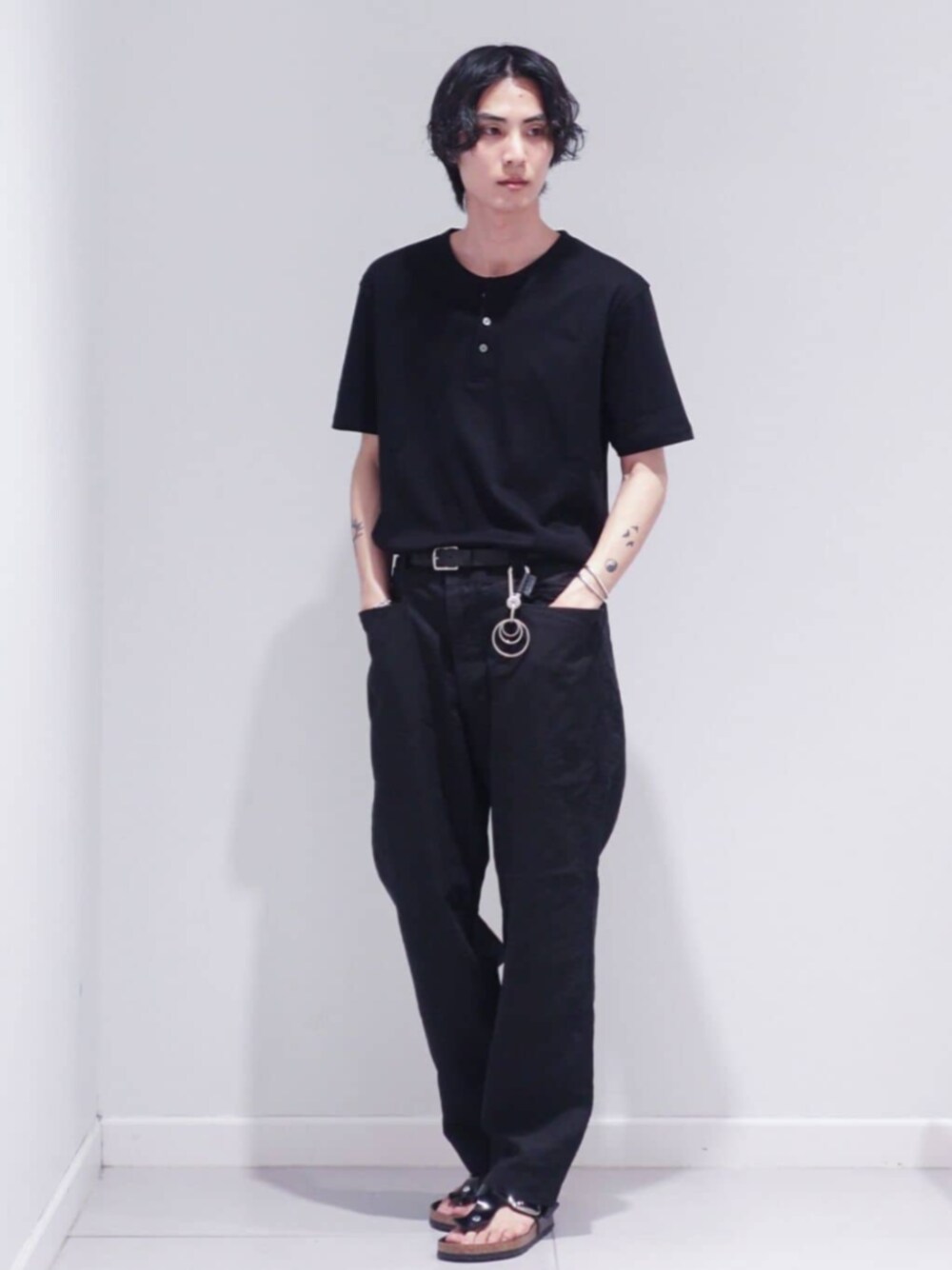 ブラック系のサンダル、ブラック系のスラックス、ブラック系のTシャツ/カットソーを着用したメンズの夏コーディネートの1枚目の写真