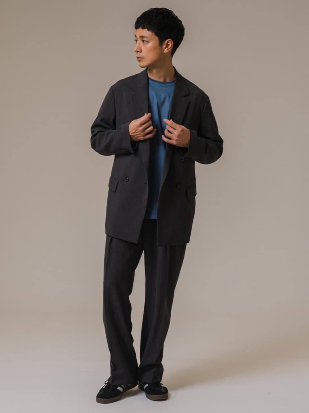 グレー系のテーラードジャケット、グレー系のスラックスを着用したメンズの冬コーディネートの1枚目の写真