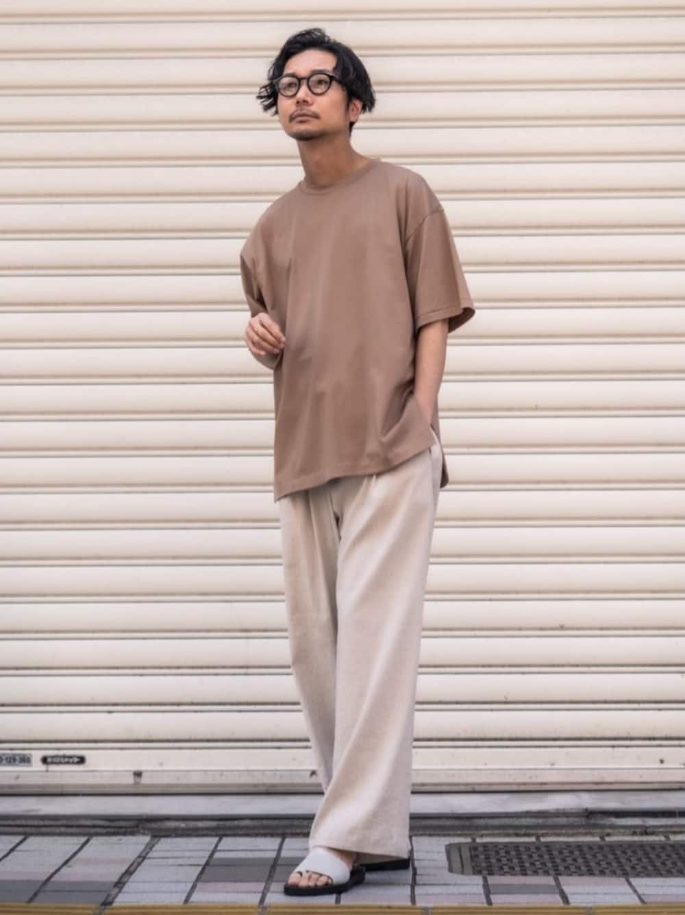 ホワイト系のスラックス、その他のサンダル、イエロー系のTシャツ/カットソーを着用したメンズの春コーディネートの1枚目の写真