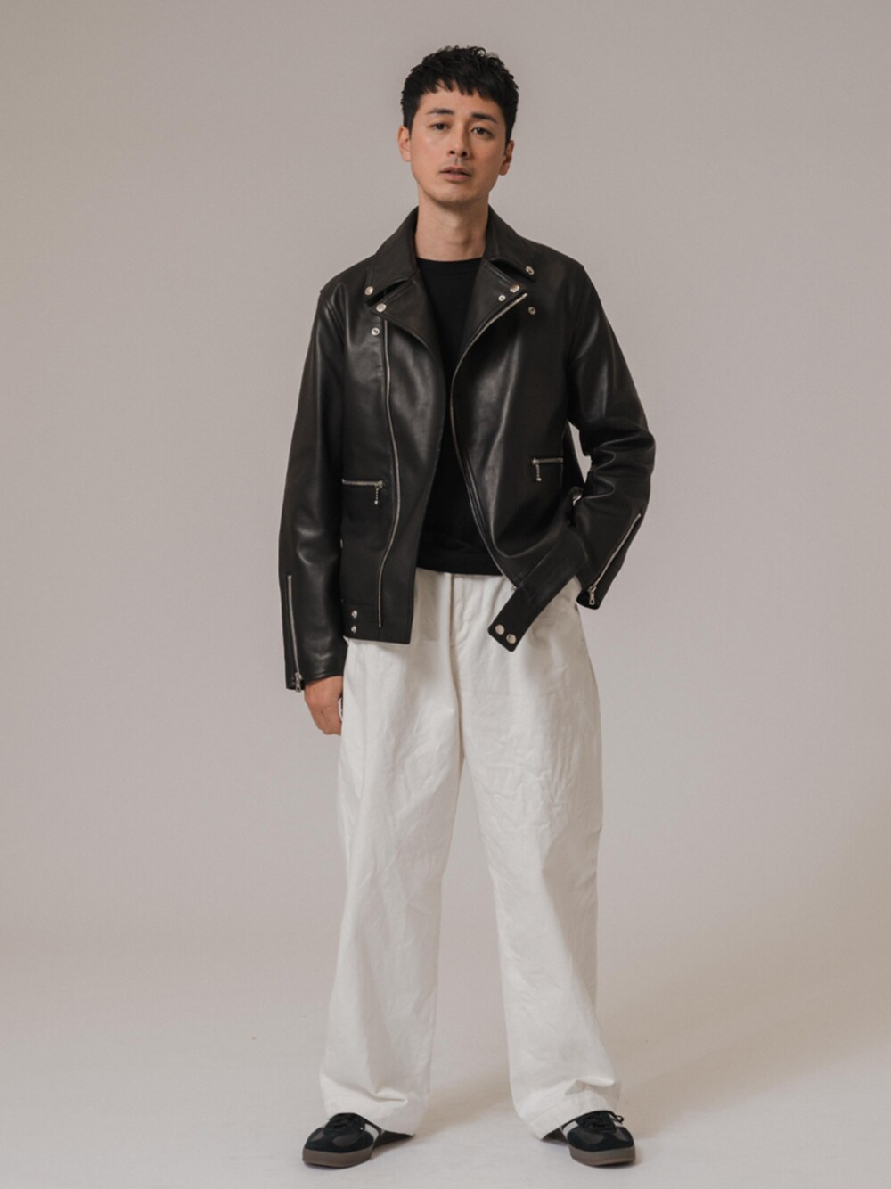 ブラック系のニット/セーター、ブラック系のスニーカー、ブラック系のライダースジャケットを着用したメンズの冬コーディネートの1枚目の写真