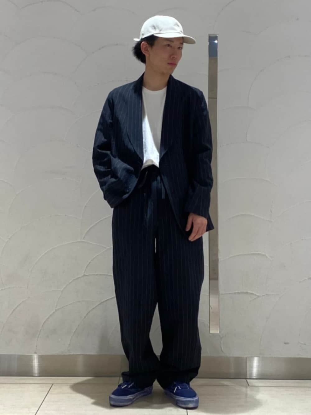 ブラック系のテーラードジャケット、ブラック系のスラックス、ベージュ系のハットを着用したメンズの春コーディネートの1枚目の写真