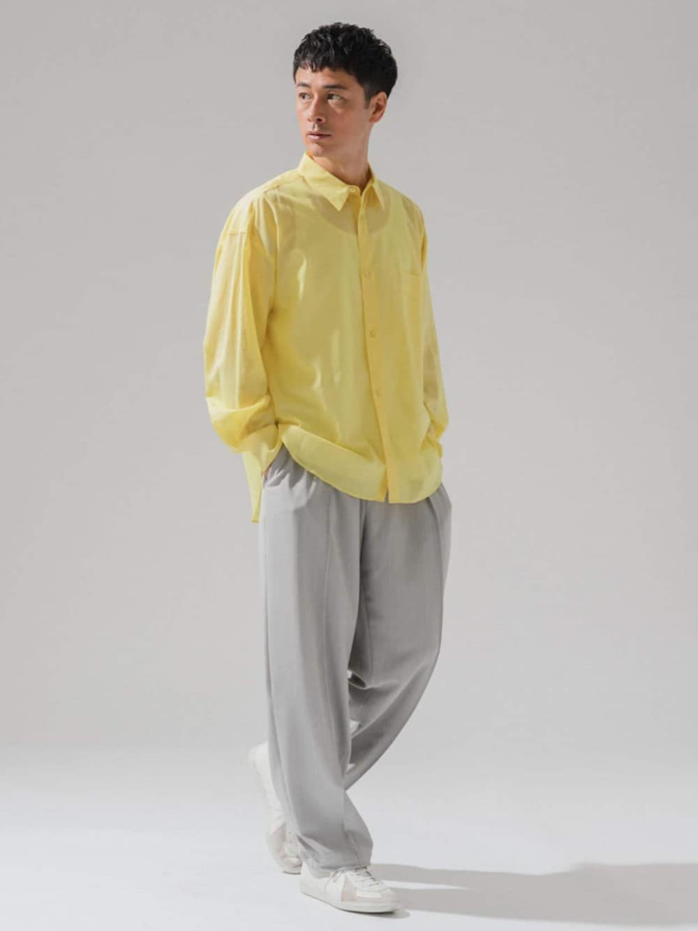 グレー系のスラックス、イエロー系のシャツ/ブラウスを着用したメンズの春コーディネートの1枚目の写真