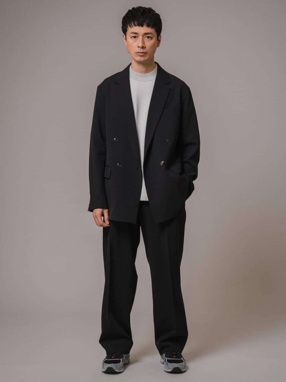 ブラック系のテーラードジャケット、ブラック系のスラックスを着用したメンズの冬コーディネートの1枚目の写真