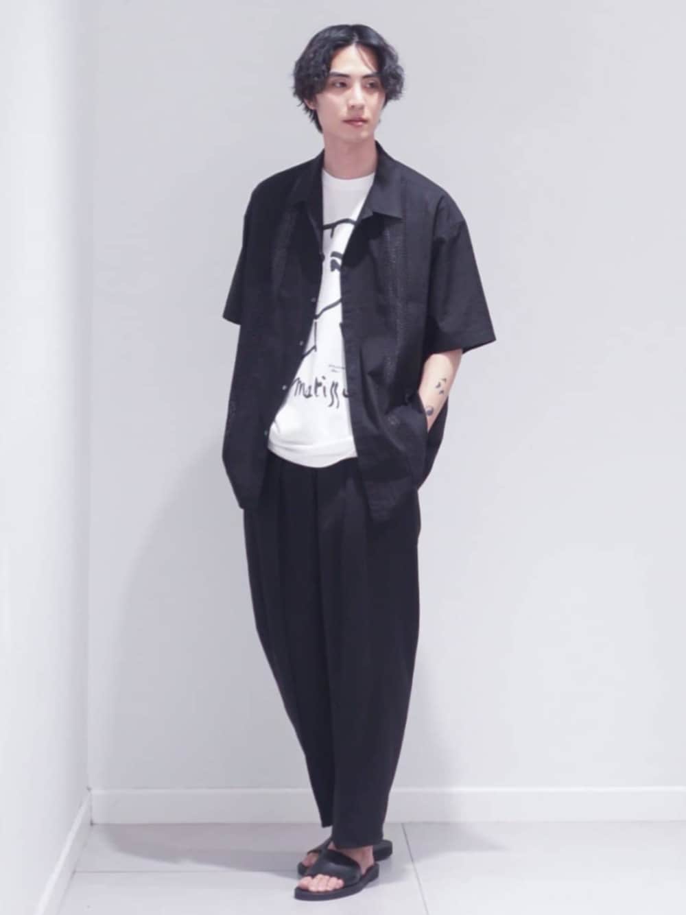 ブラック系のスラックス、ブラック系のシャツ/ブラウス、ホワイト系のTシャツ/カットソーを着用したメンズの夏コーディネートの1枚目の写真