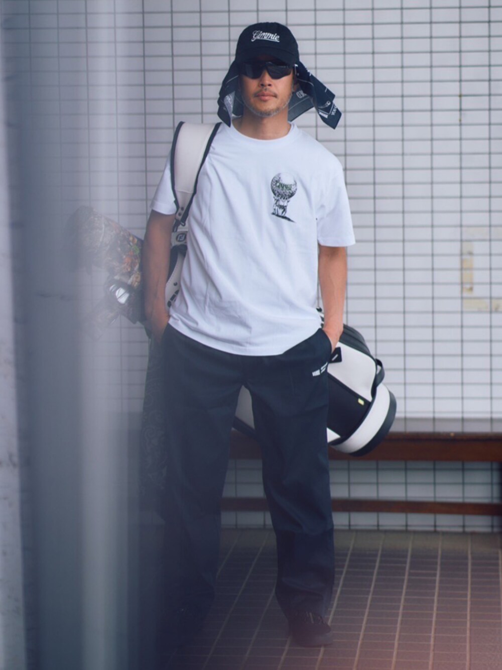 ホワイト系のTシャツ/カットソー、ブラック系のスラックスを着用したメンズの夏コーディネートの1枚目の写真