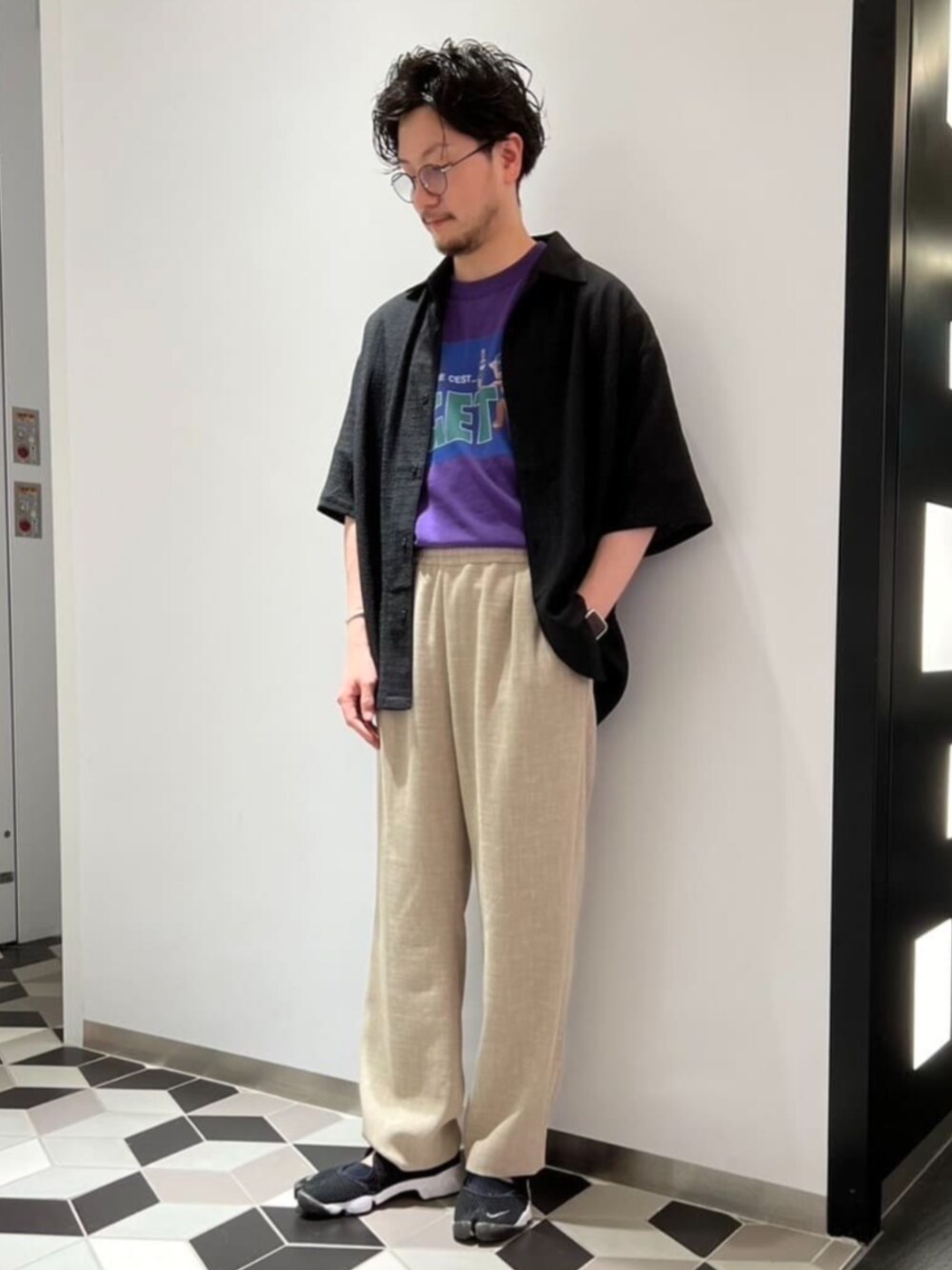 ベージュ系のスラックス、ブラック系のシャツ/ブラウス、パープル系のTシャツ/カットソーを着用したメンズの夏コーディネートの1枚目の写真