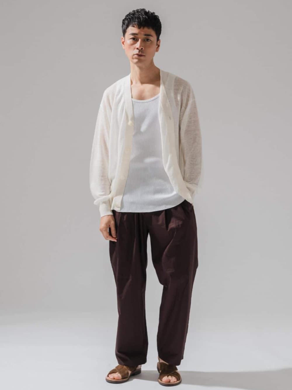 ブラウン系のスラックス、ホワイト系のカーディガン/ボレロを着用したメンズの春コーディネートの1枚目の写真