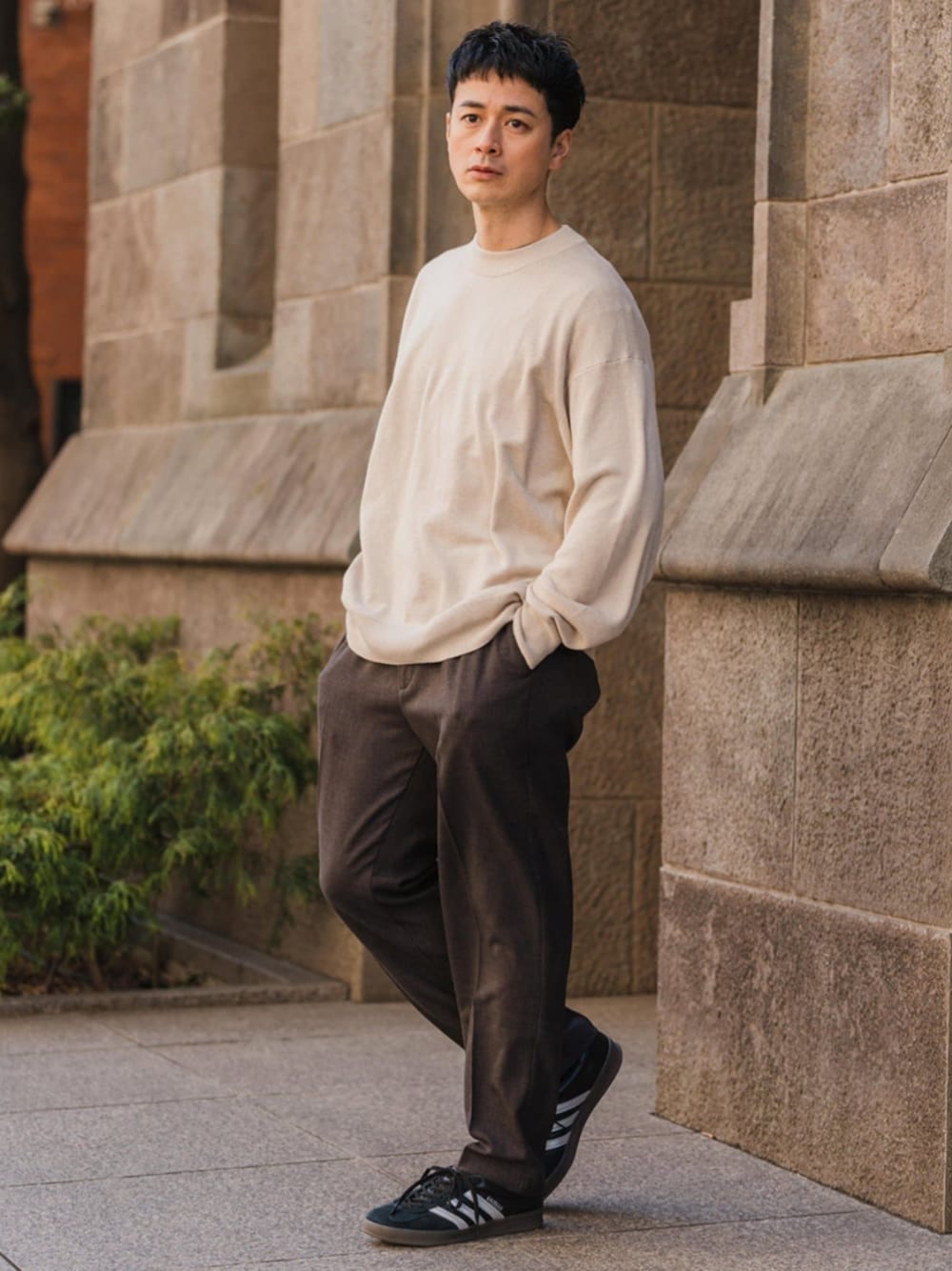 ベージュ系のニット/セーター、ベージュ系のスラックスを着用したメンズの春コーディネートの1枚目の写真