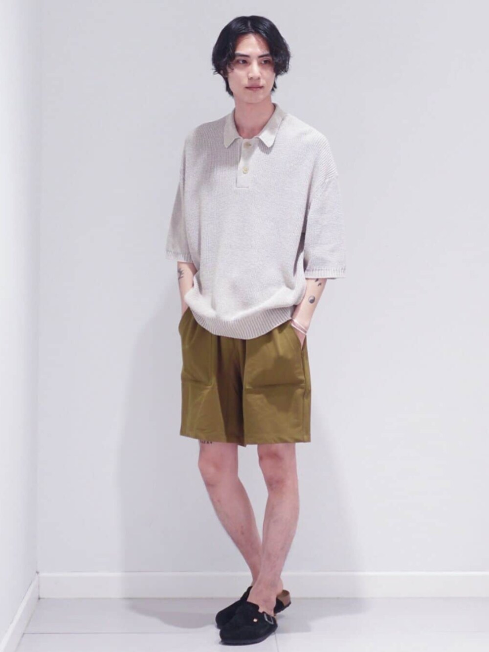 ホワイト系のポロシャツ、イエロー系のその他パンツを着用したメンズの夏コーディネートの1枚目の写真