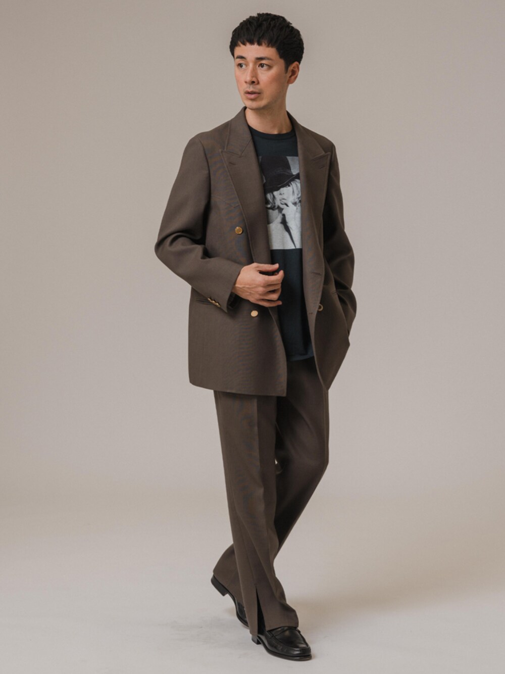 ブラウン系のテーラードジャケット、ブラウン系のスラックスを着用したメンズの冬コーディネートの1枚目の写真