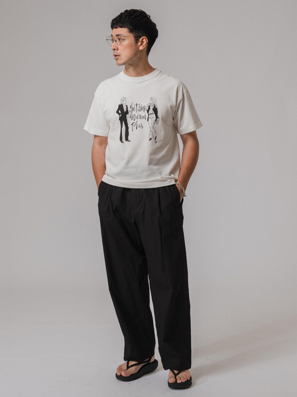 ブラック系のサンダル、ホワイト系のTシャツ/カットソー、ブラック系のスラックスを着用したメンズの夏コーディネートの1枚目の写真