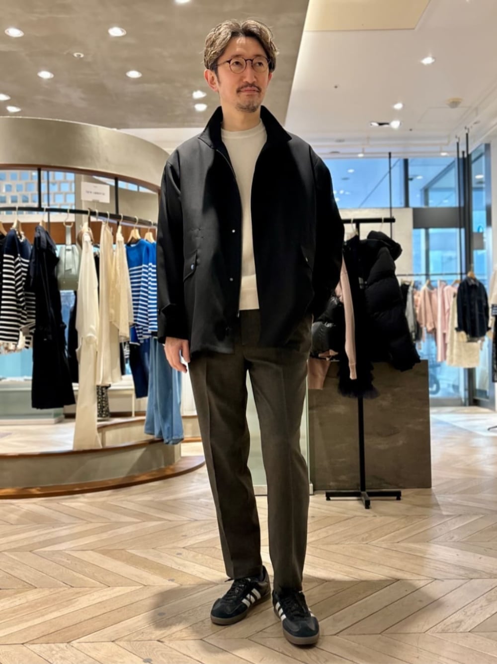 ブラック系のその他アウター、グレー系のスラックスを着用したメンズの冬コーディネートの1枚目の写真