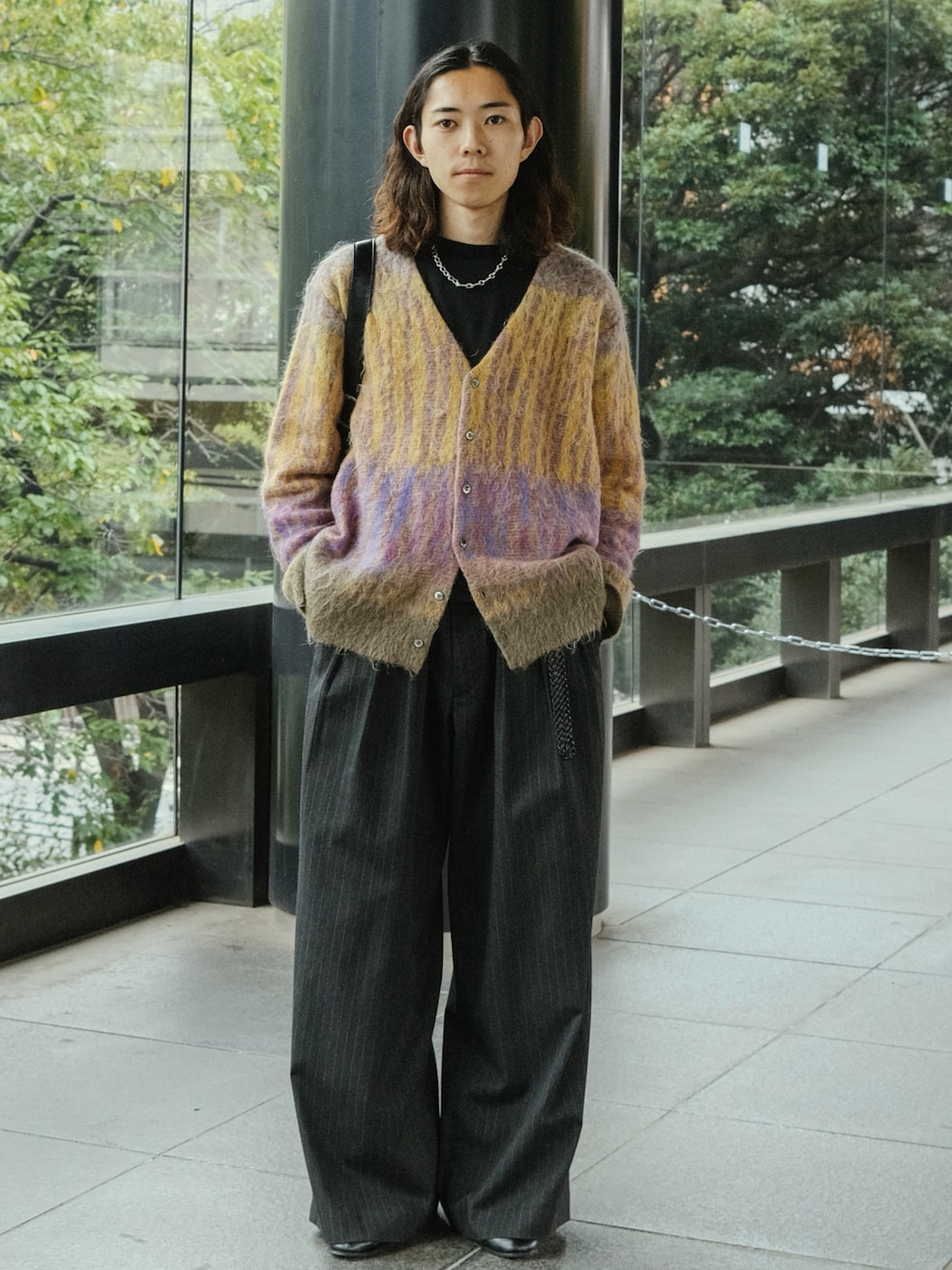 グレー系のスラックス、ブラック系のドレスシューズ、ブラック系のショルダーバッグを着用したメンズの秋コーディネートの1枚目の写真