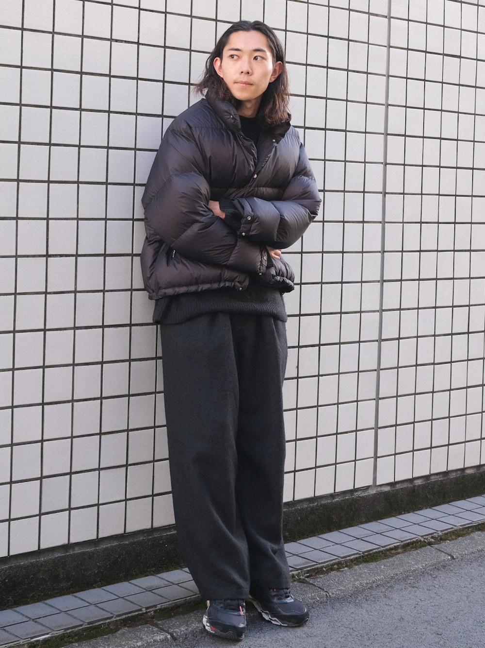 ブラック系のダウンジャケット/コート、ブラック系のニット/セーター、ブラック系のスラックスを着用したメンズの冬コーディネートの1枚目の写真