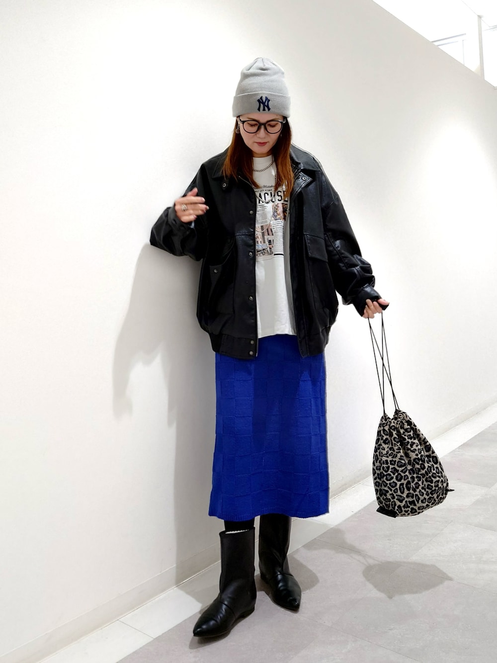 ブラック系のブルゾン、ブラック系のブーツ、ブルー系のスカートを着用したレディースの秋コーディネートの1枚目の写真