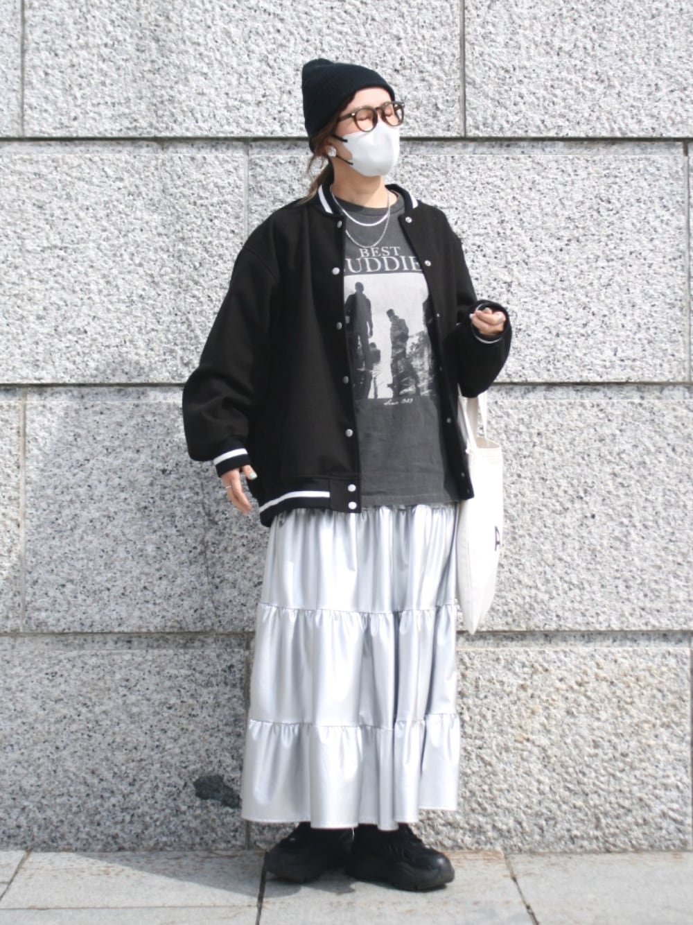 シルバー系のスカート、ブラック系のブルゾン、その他のTシャツ/カットソーを着用したレディースの春コーディネートの1枚目の写真