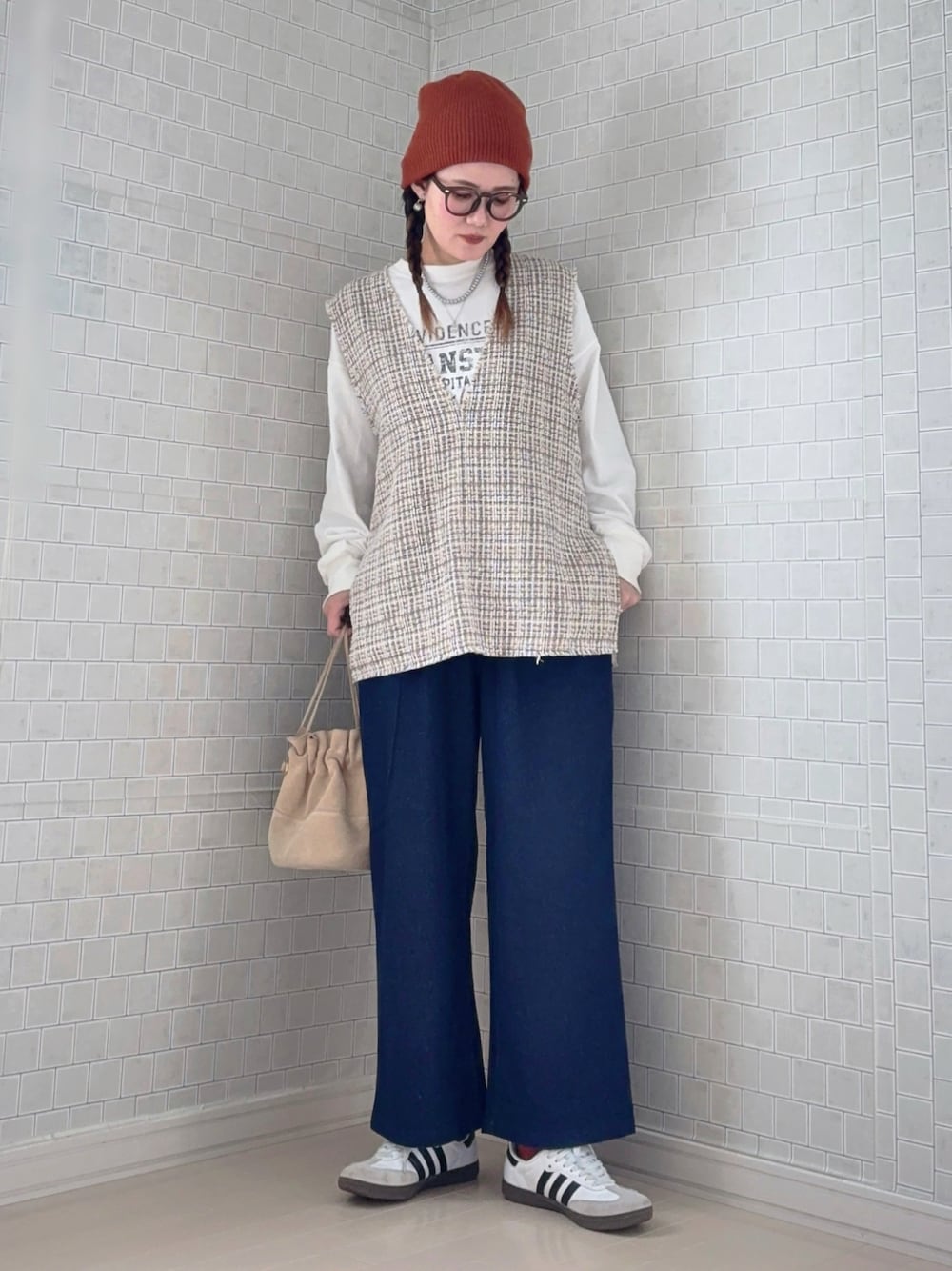 ブルー系のチノパンツ、ホワイト系のスニーカー、ブラウン系のニットキャップ/ビーニーを着用したレディースの冬コーディネートの1枚目の写真