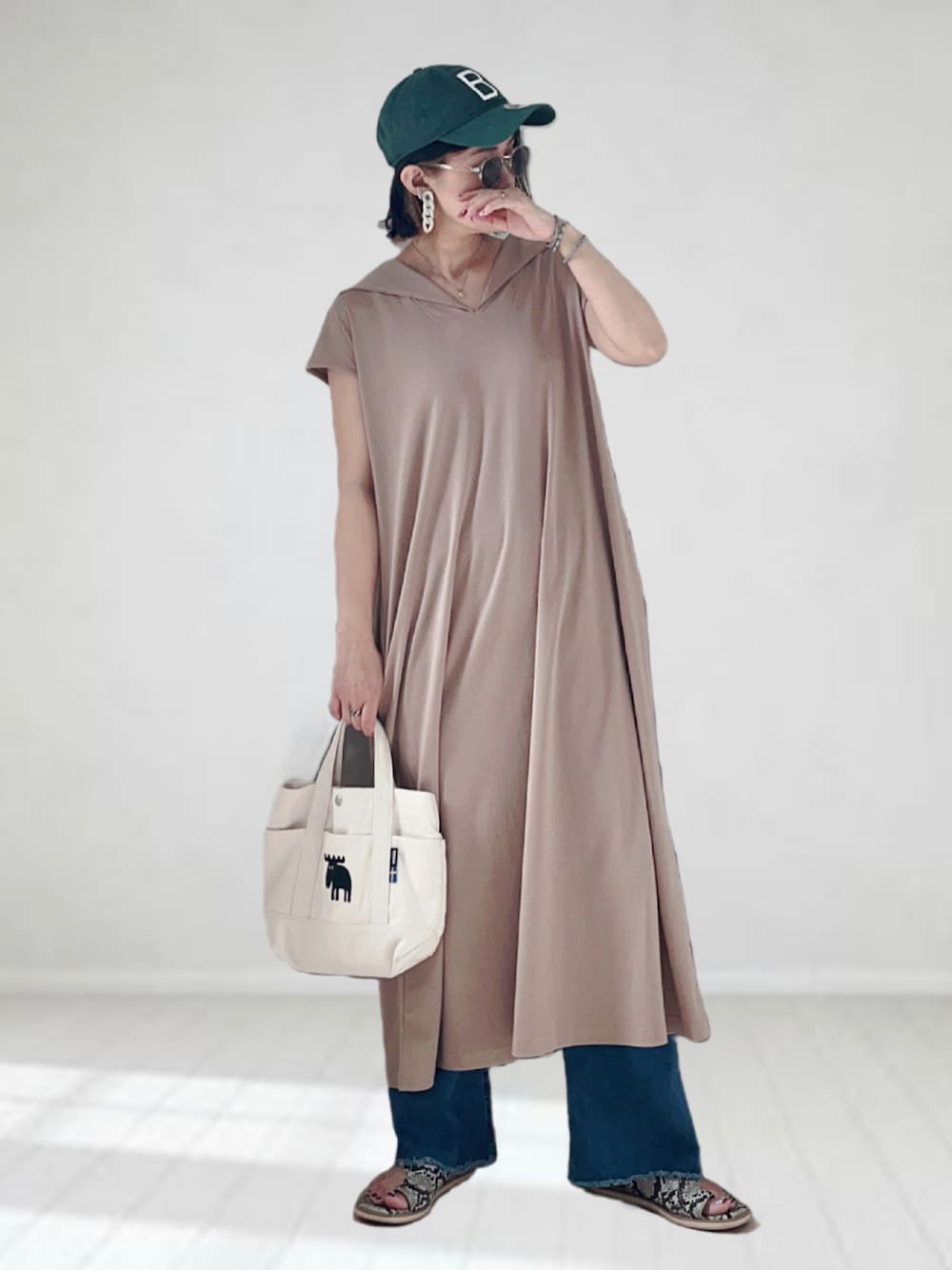 ベージュ系のワンピース、ブルー系のデニムパンツ、ホワイト系のトートバッグを着用したレディースの夏コーディネートの1枚目の写真