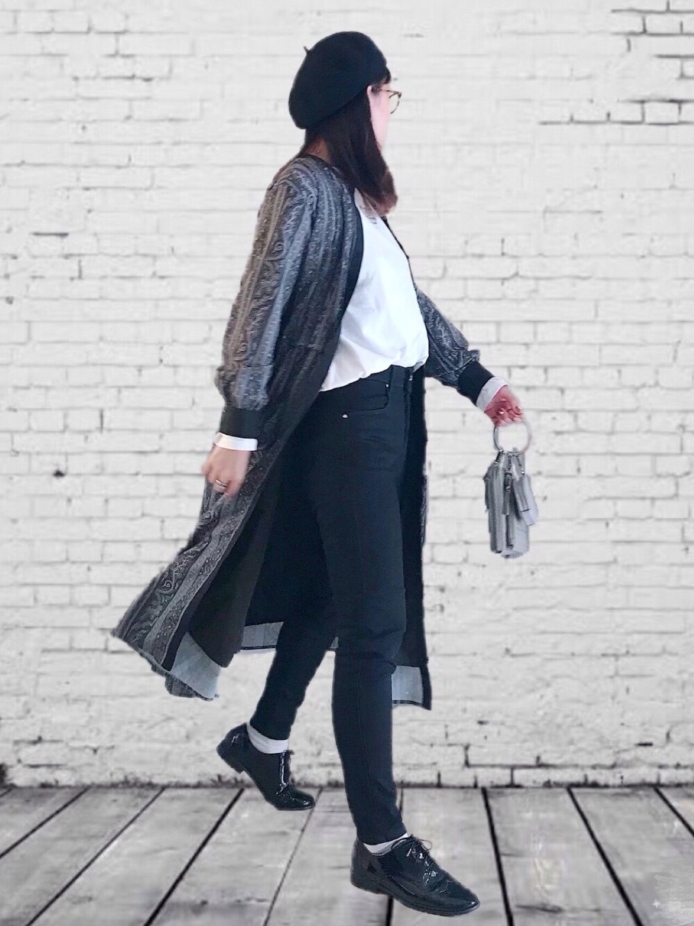 ブラック系のワンピース、ブラック系のデニムパンツ、ホワイト系のTシャツ/カットソーを着用したレディースの秋コーディネートの1枚目の写真