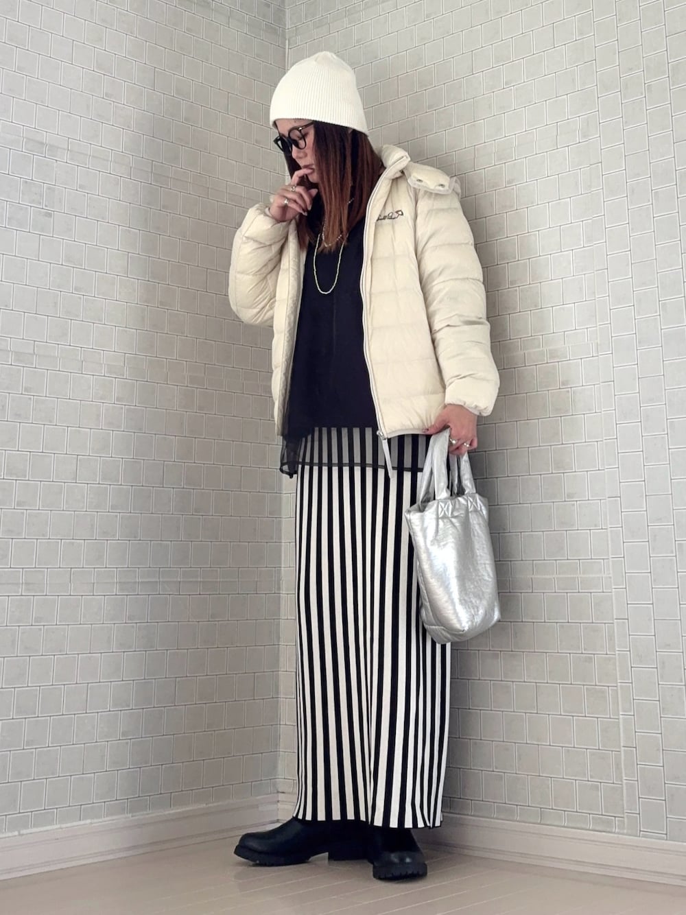 ホワイト系のダウンジャケット/コート、ブラック系のスウェット、ホワイト系のスカートを着用したレディースの秋コーディネートの1枚目の写真