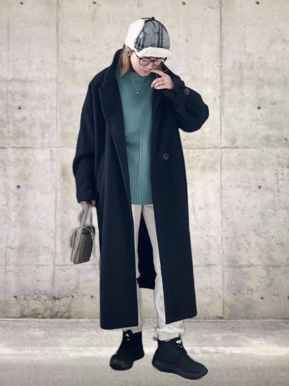 ブラック系のその他アウター、グリーン系のニット/セーター、ホワイト系のスウェットパンツを着用したレディースの冬コーディネートの1枚目の写真