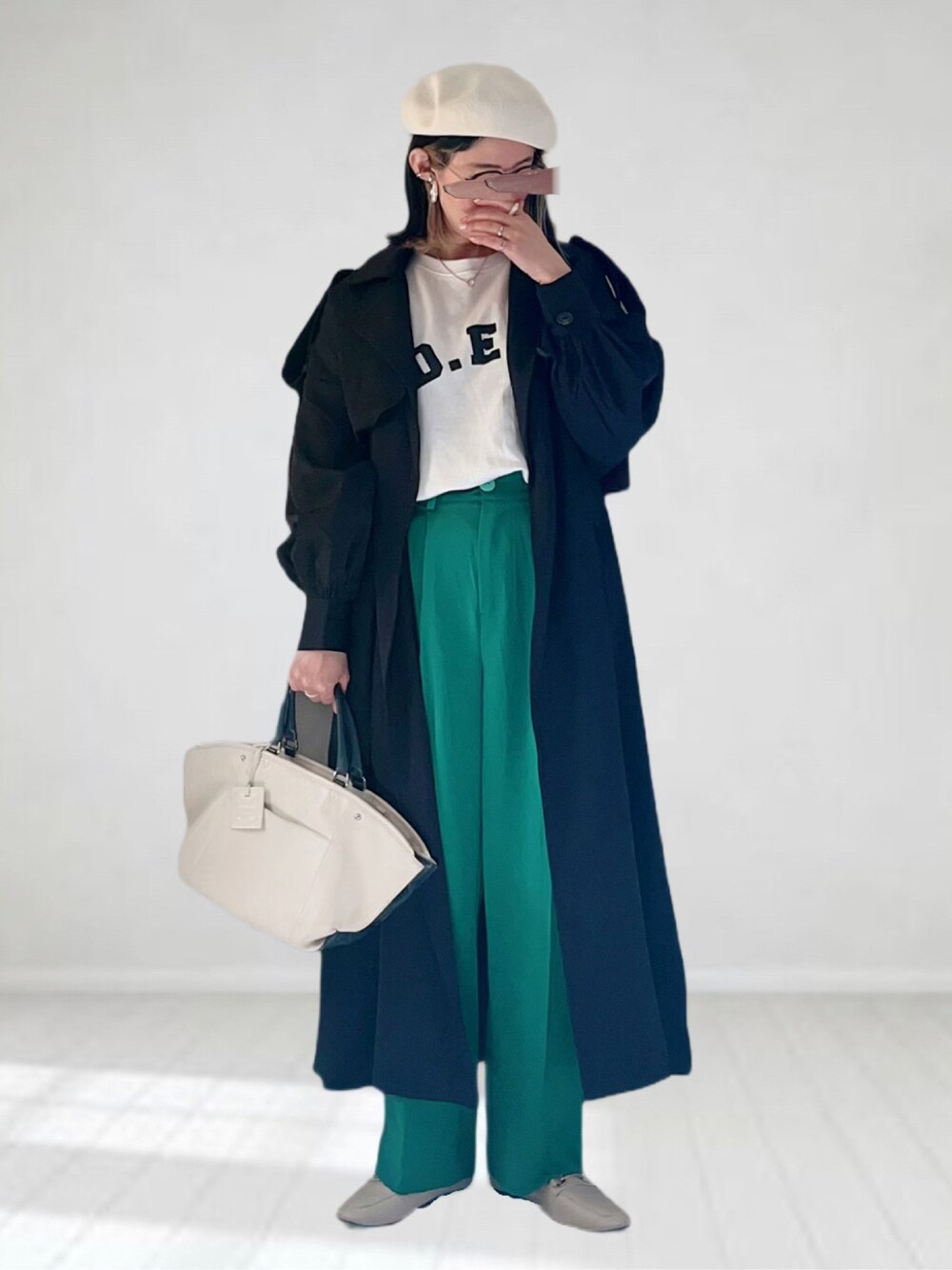 ブラック系のトレンチコート、ホワイト系のTシャツ/カットソー、ホワイト系のバッグを着用したレディースの春コーディネートの1枚目の写真