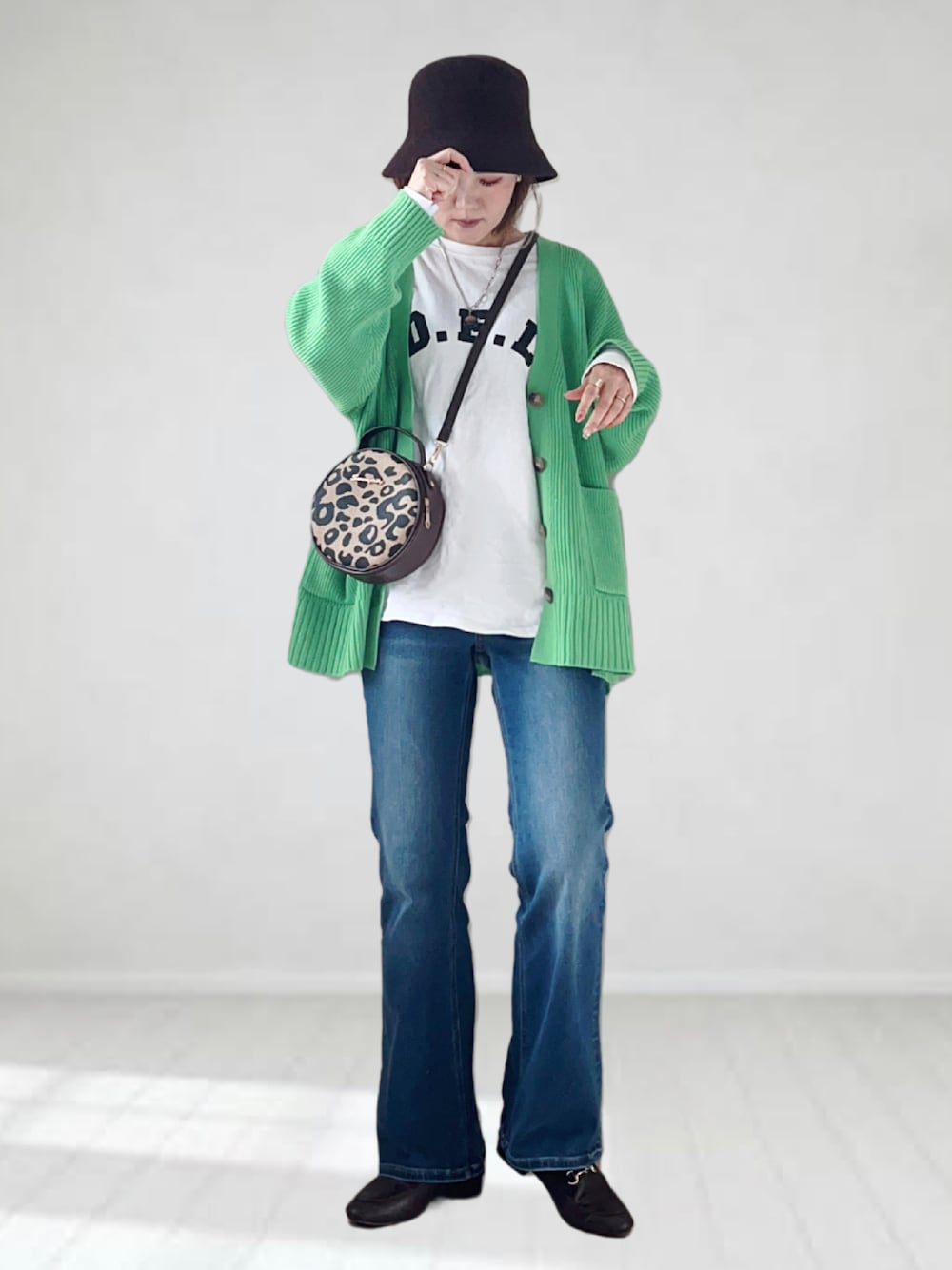 ブルー系のデニムパンツ、ホワイト系のTシャツ/カットソー、グリーン系のカーディガン/ボレロを着用したレディースの春コーディネートの1枚目の写真