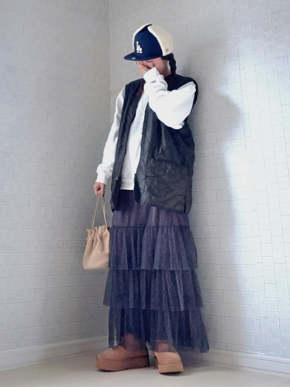 その他のスカート、ブラウン系のブーツ、グリーン系のベストを着用したレディースの冬コーディネートの1枚目の写真