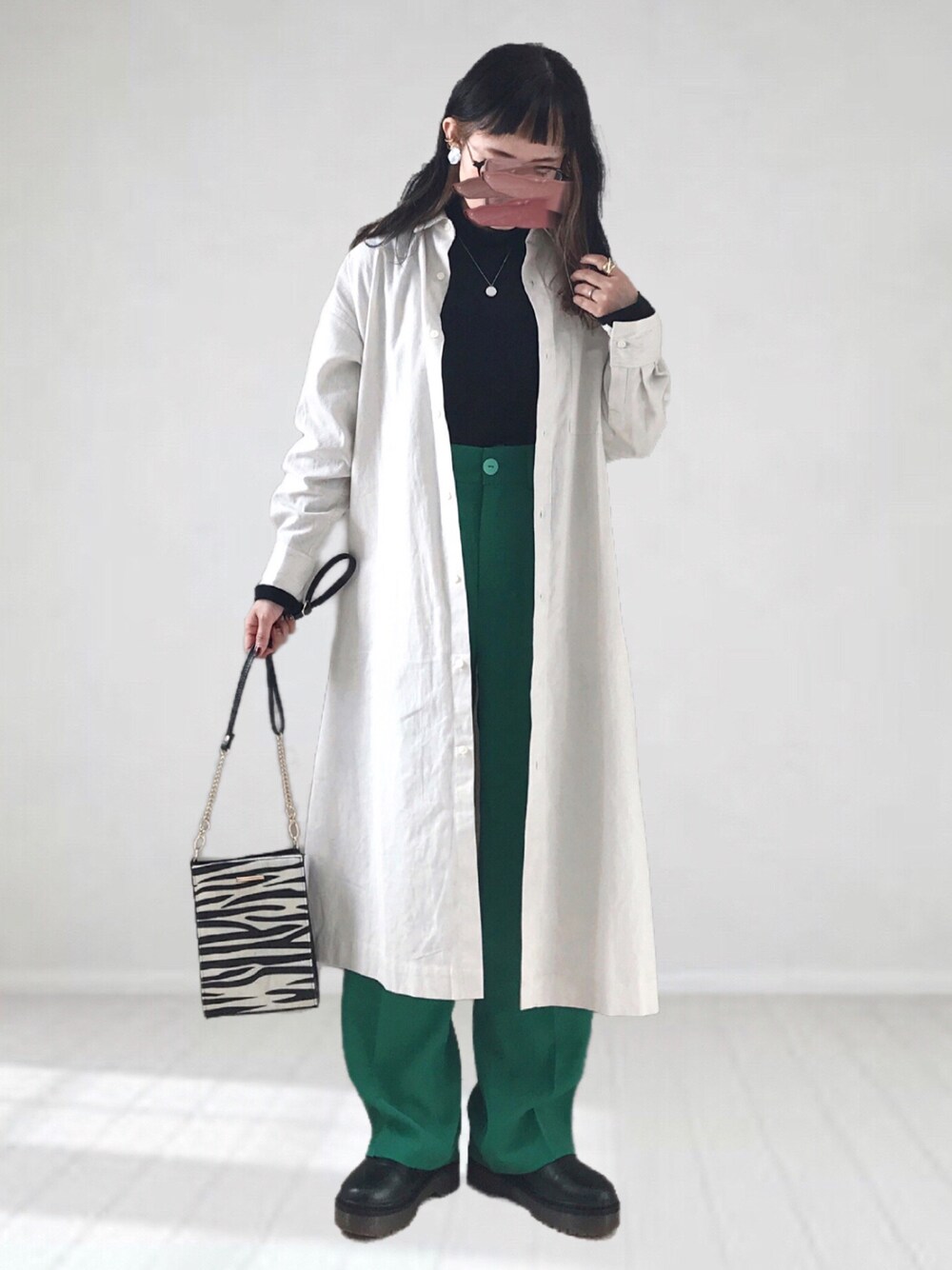 ベージュ系のワンピース、ブラック系のTシャツ/カットソー、ホワイト系のショルダーバッグを着用したレディースの冬コーディネートの1枚目の写真