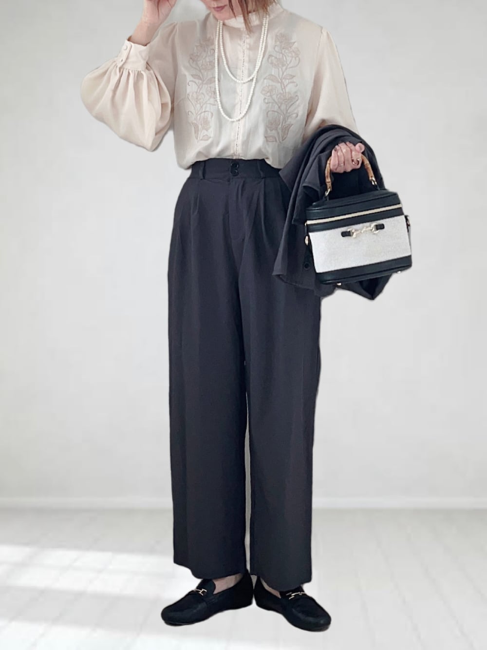 グレー系のテーラードジャケット、ホワイト系のシャツ/ブラウス、ホワイト系のハンドバッグを着用したレディースの冬コーディネートの1枚目の写真