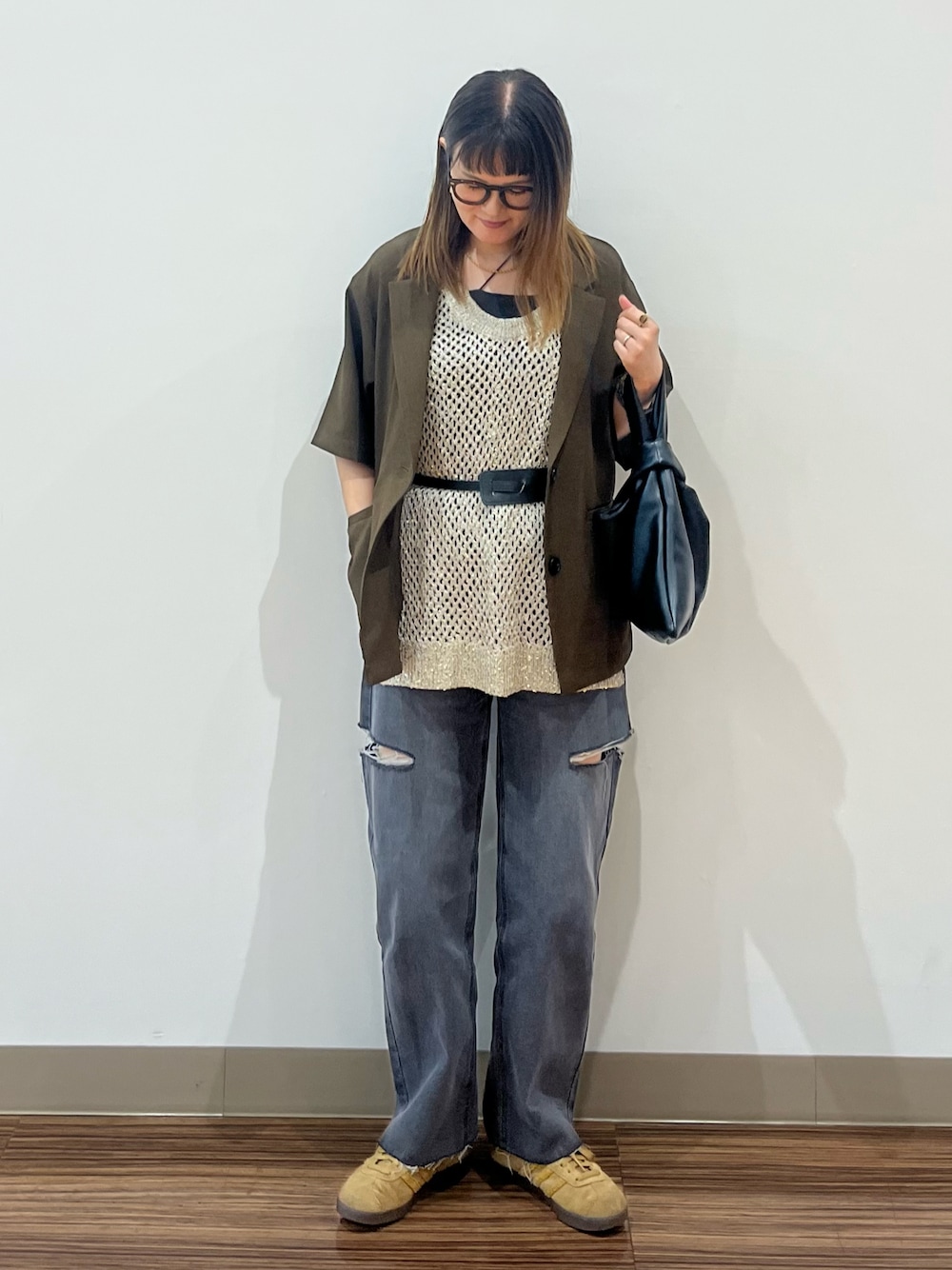 ブラック系のデニムパンツ、ブラウン系のテーラードジャケット、ゴールド系のベストを着用したレディースの夏コーディネートの1枚目の写真