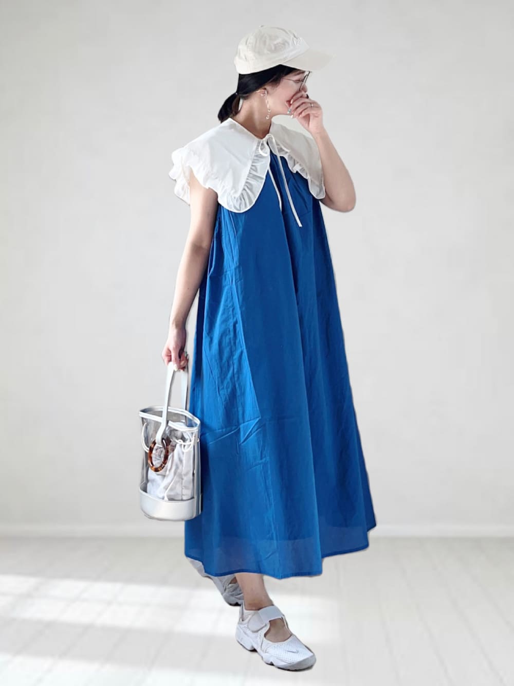 ブルー系のワンピース、ホワイト系のシャツ/ブラウス、シルバー系のショルダーバッグを着用したレディースの春コーディネートの1枚目の写真