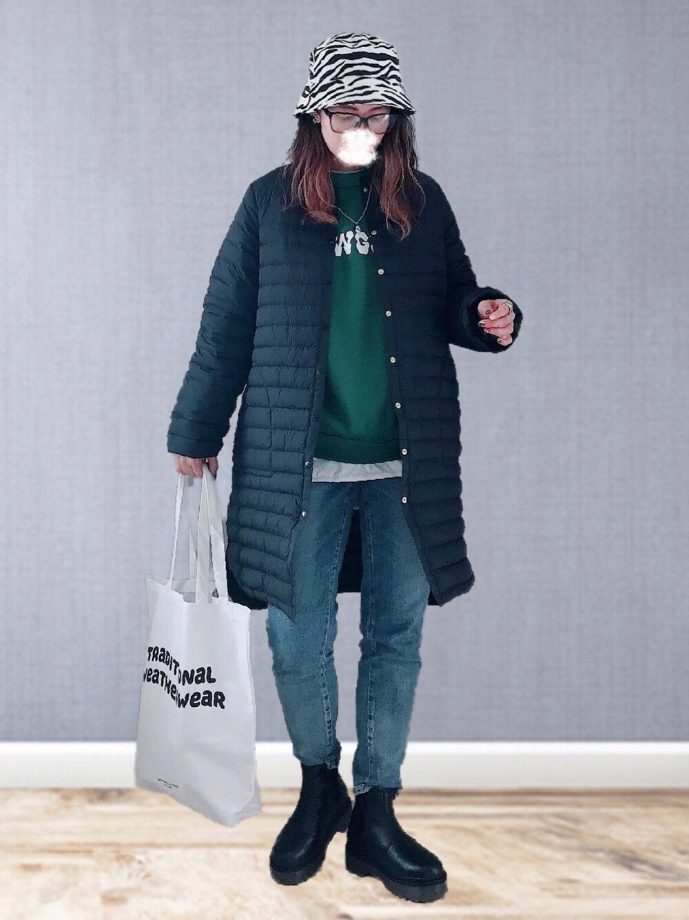 ブラック系のダウンジャケット/コート、グリーン系のスウェット、ホワイト系のTシャツ/カットソーを着用したレディースの冬コーディネートの1枚目の写真