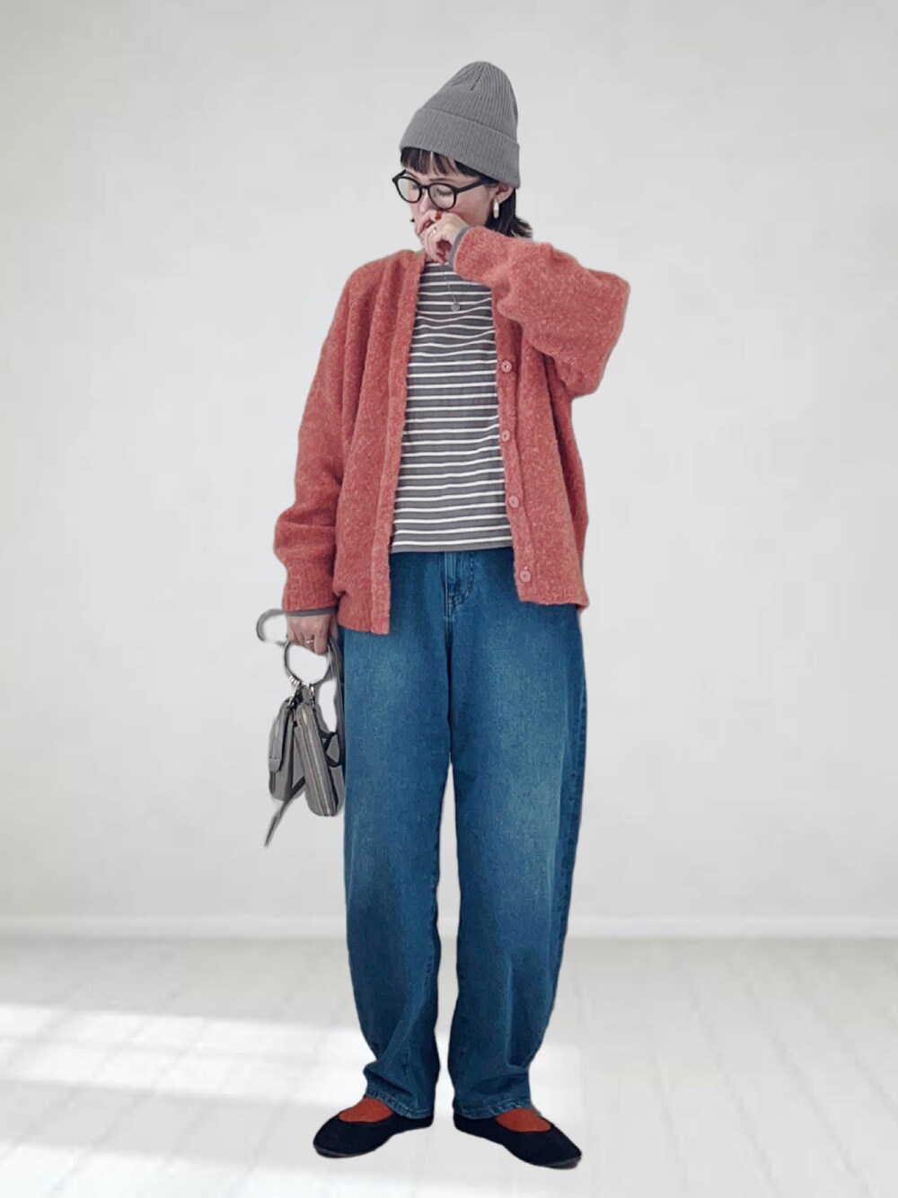 グレー系のTシャツ/カットソー、ピンク系のカーディガン/ボレロ、ブルー系のデニムパンツを着用したレディースの秋コーディネートの1枚目の写真