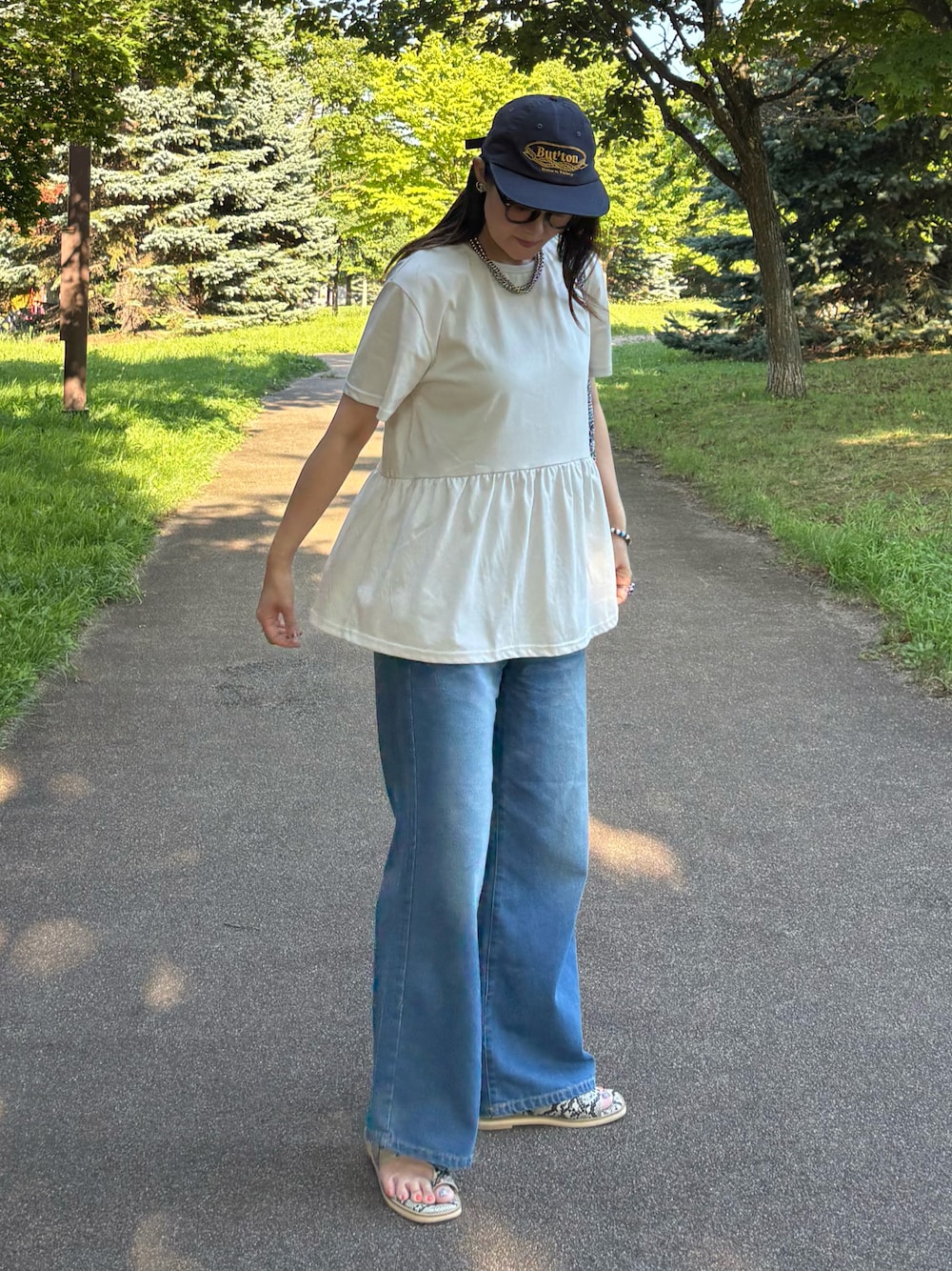 グレー系のTシャツ/カットソー、ブルー系のかごバッグ、ブルー系のデニムパンツを着用したレディースの夏コーディネートの1枚目の写真