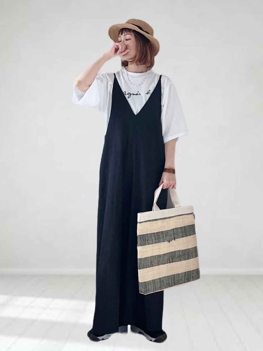ホワイト系のTシャツ/カットソー、ブラック系のトートバッグ、ブラック系のサロペット/オーバーオールを着用したレディースの春コーディネートの1枚目の写真