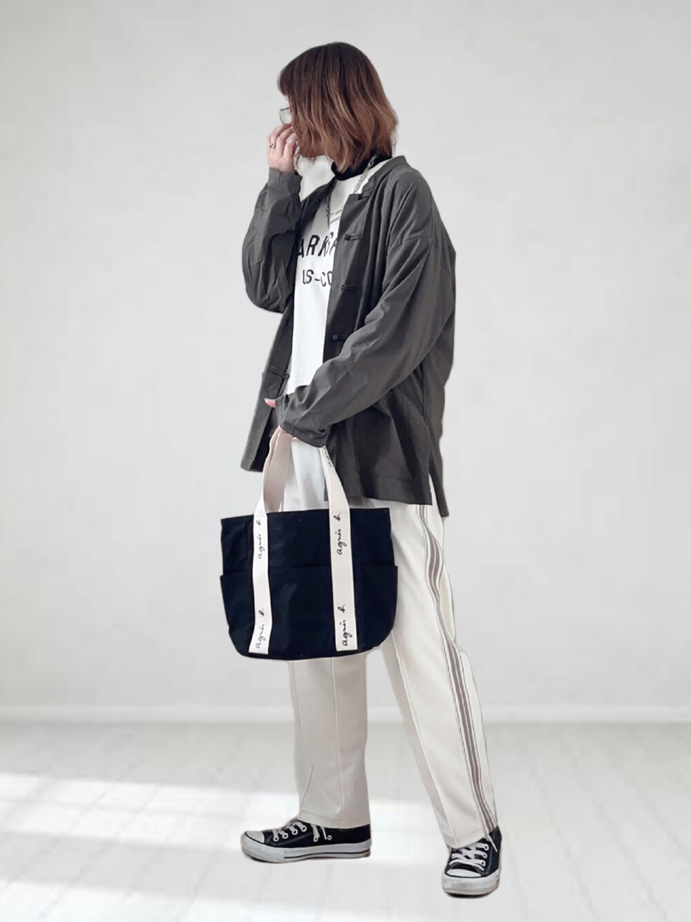 ブラック系のトートバッグ、ブラック系のTシャツ/カットソー、ホワイト系のスウェットを着用したレディースの春コーディネートの1枚目の写真