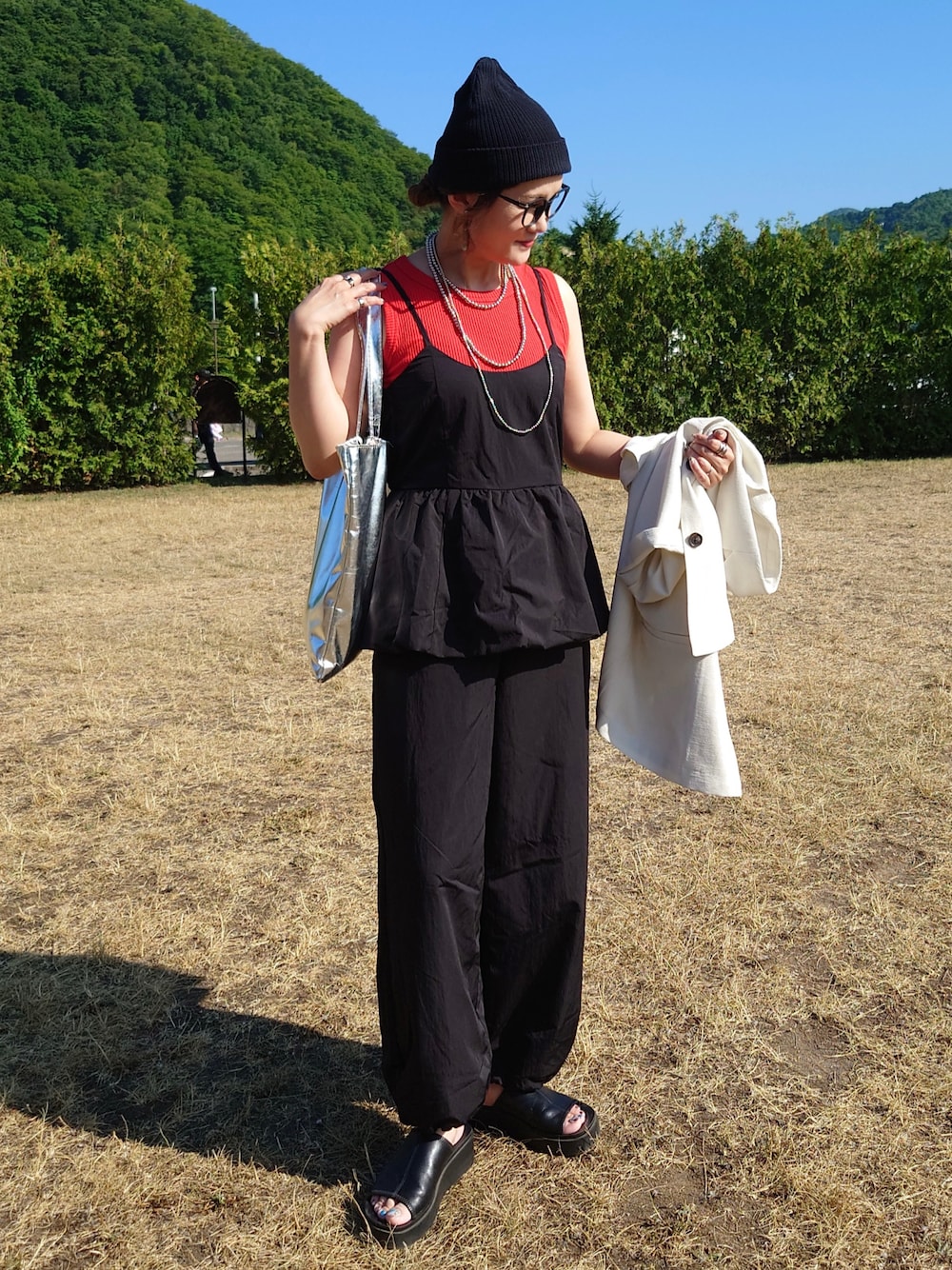 ブラック系のサロペット/オーバーオール、ホワイト系のテーラードジャケット、レッド系のTシャツ/カットソーを着用したレディースの夏コーディネートの1枚目の写真