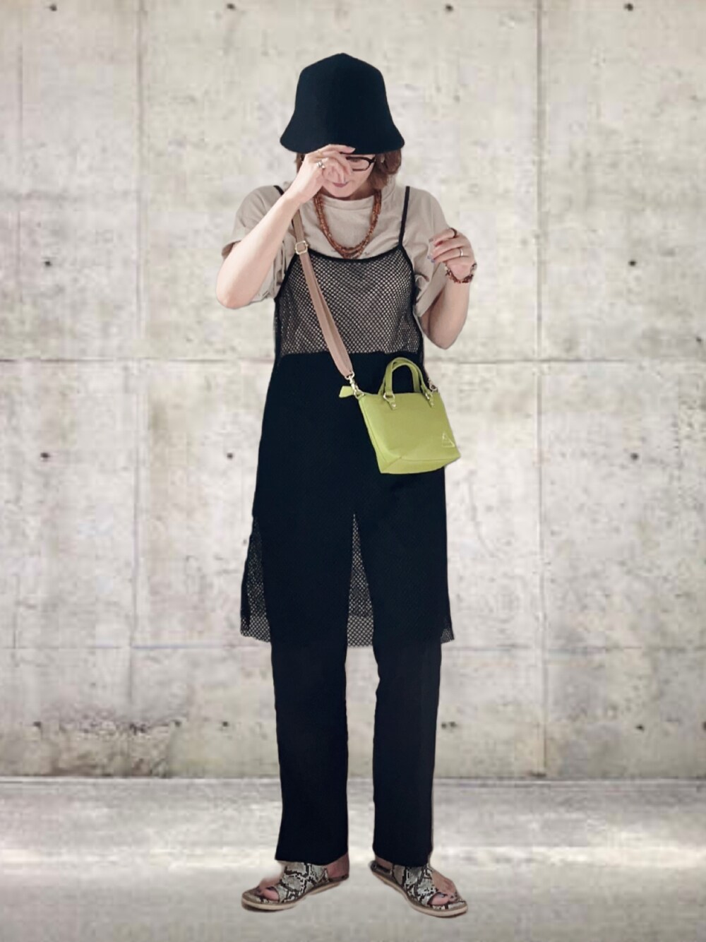 グリーン系のショルダーバッグ、ブラック系のワンピース、ベージュ系のTシャツ/カットソーを着用したレディースの夏コーディネートの1枚目の写真